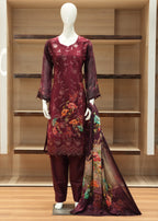 Maroon embroidered outfit with floral patterns on a mannequin against a wooden shelf background