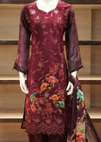 Maroon embroidered garment on a mannequin in a store setting