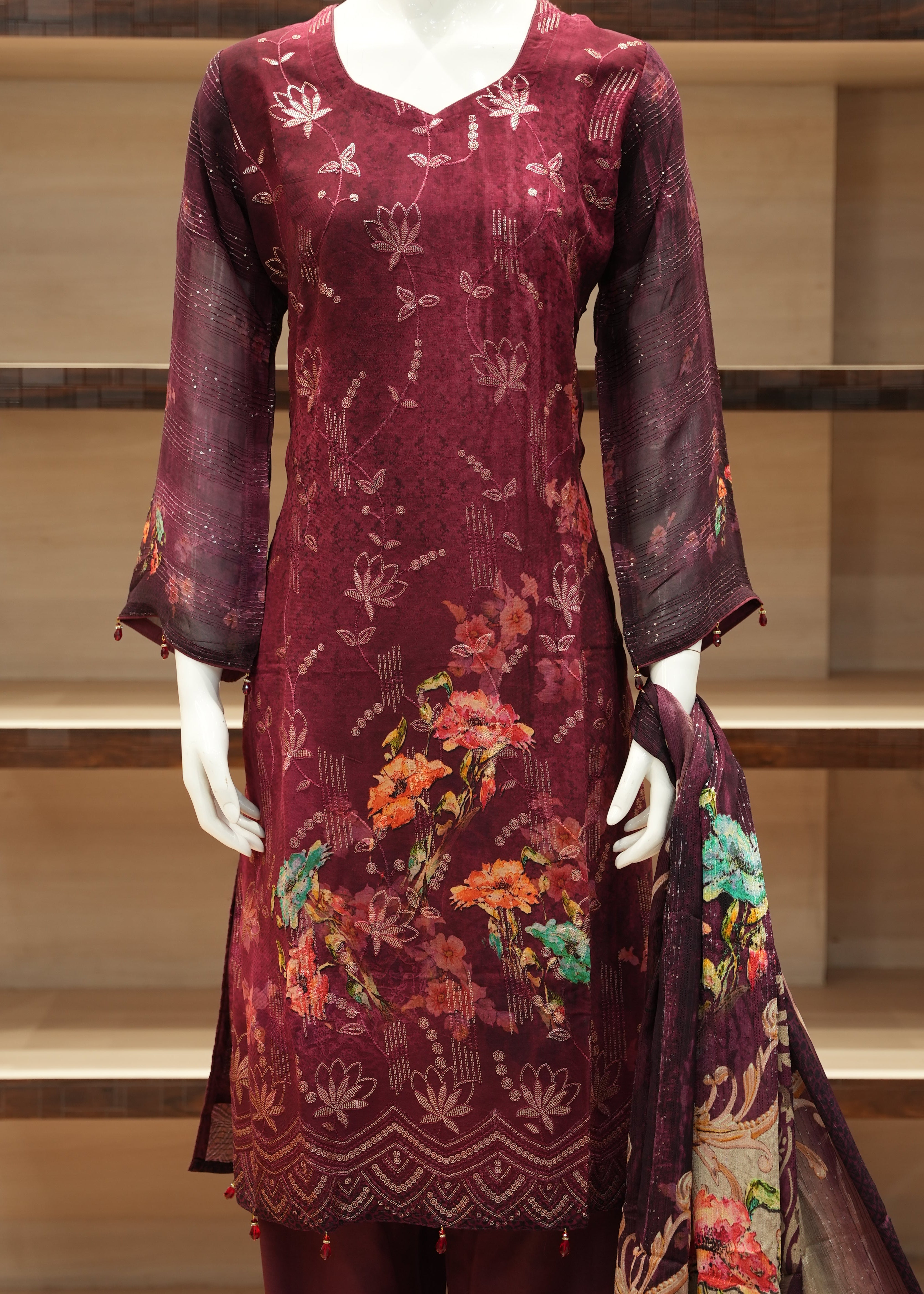 Maroon embroidered garment on a mannequin in a store setting