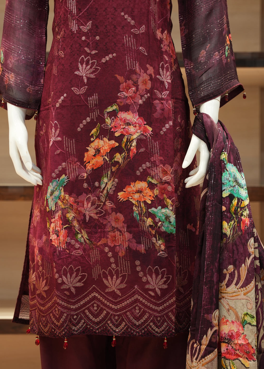 Maroon embroidered outfit with colorful floral patterns on a mannequin.