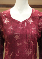 Maroon top with floral patterns on a mannequin against a blurred background