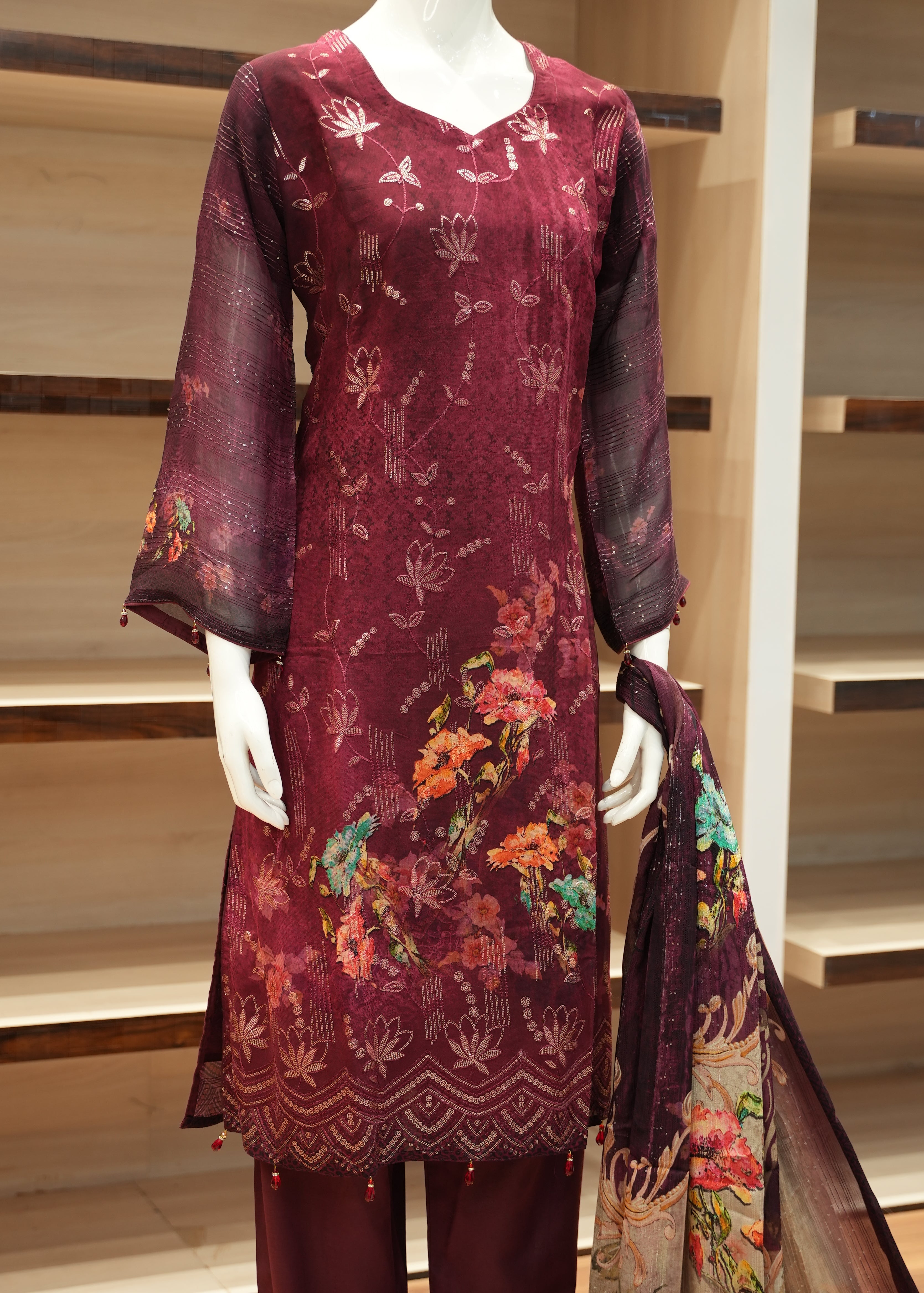 Maroon fabric with floral patterns displayed on a wooden frame.