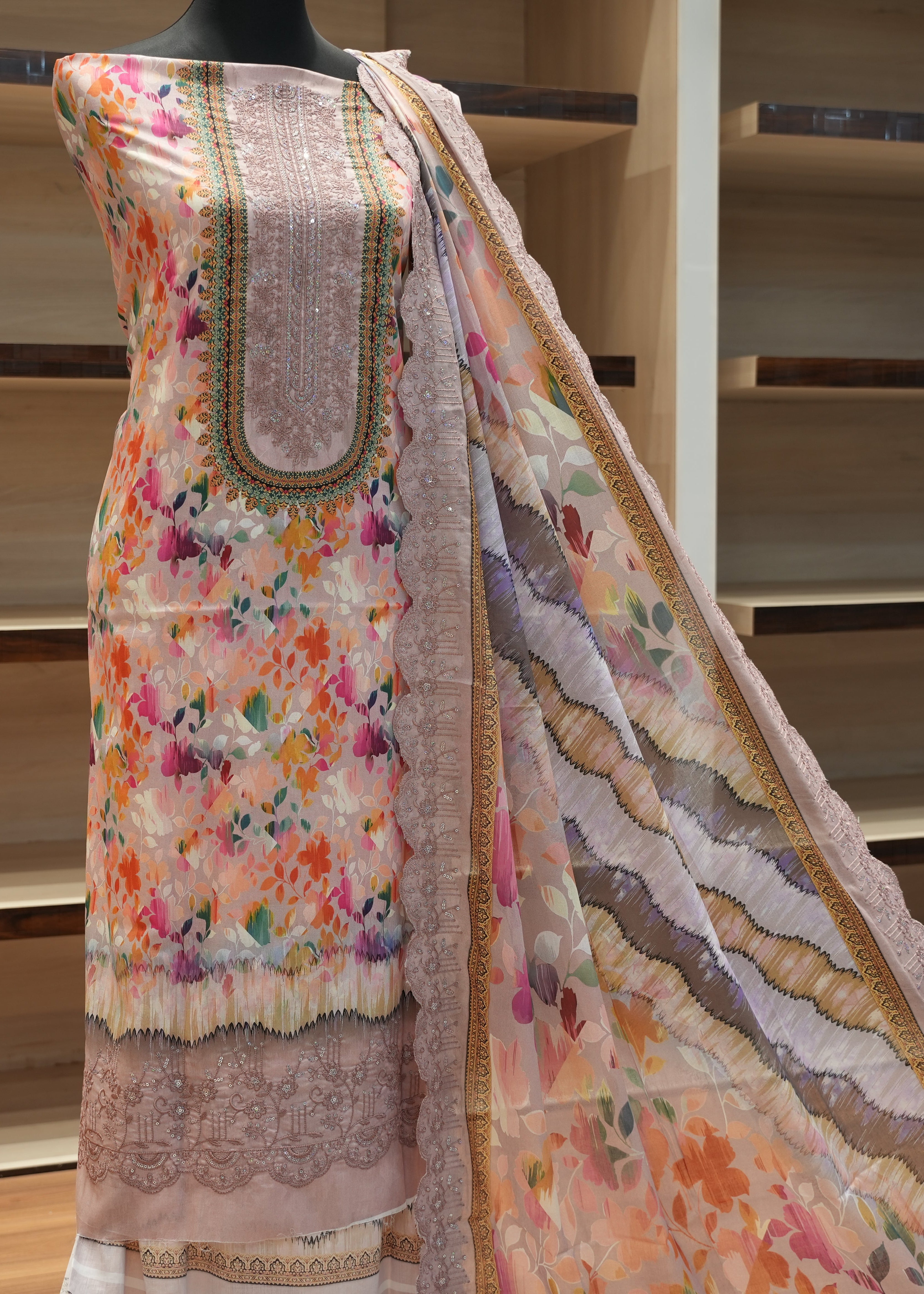 Traditional outfit with floral patterns on a mannequin against a neutral background