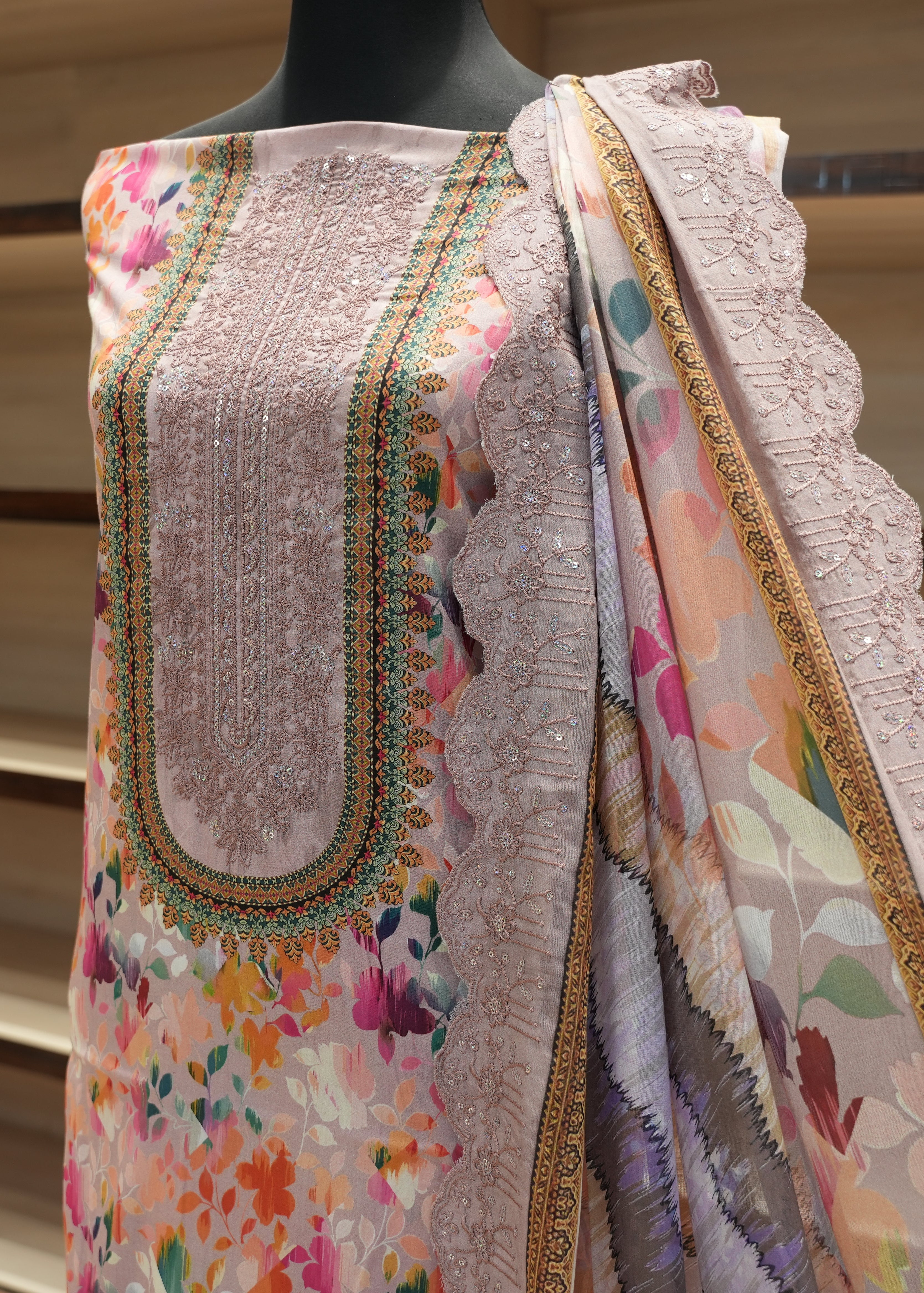 Embroidered fabric with floral patterns on a mannequin against a neutral background