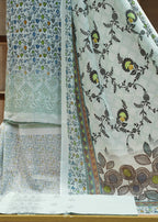 Two pieces of fabric with floral patterns on a wooden surface.