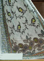 Floral patterned fabric with a colorful border on a wooden surface