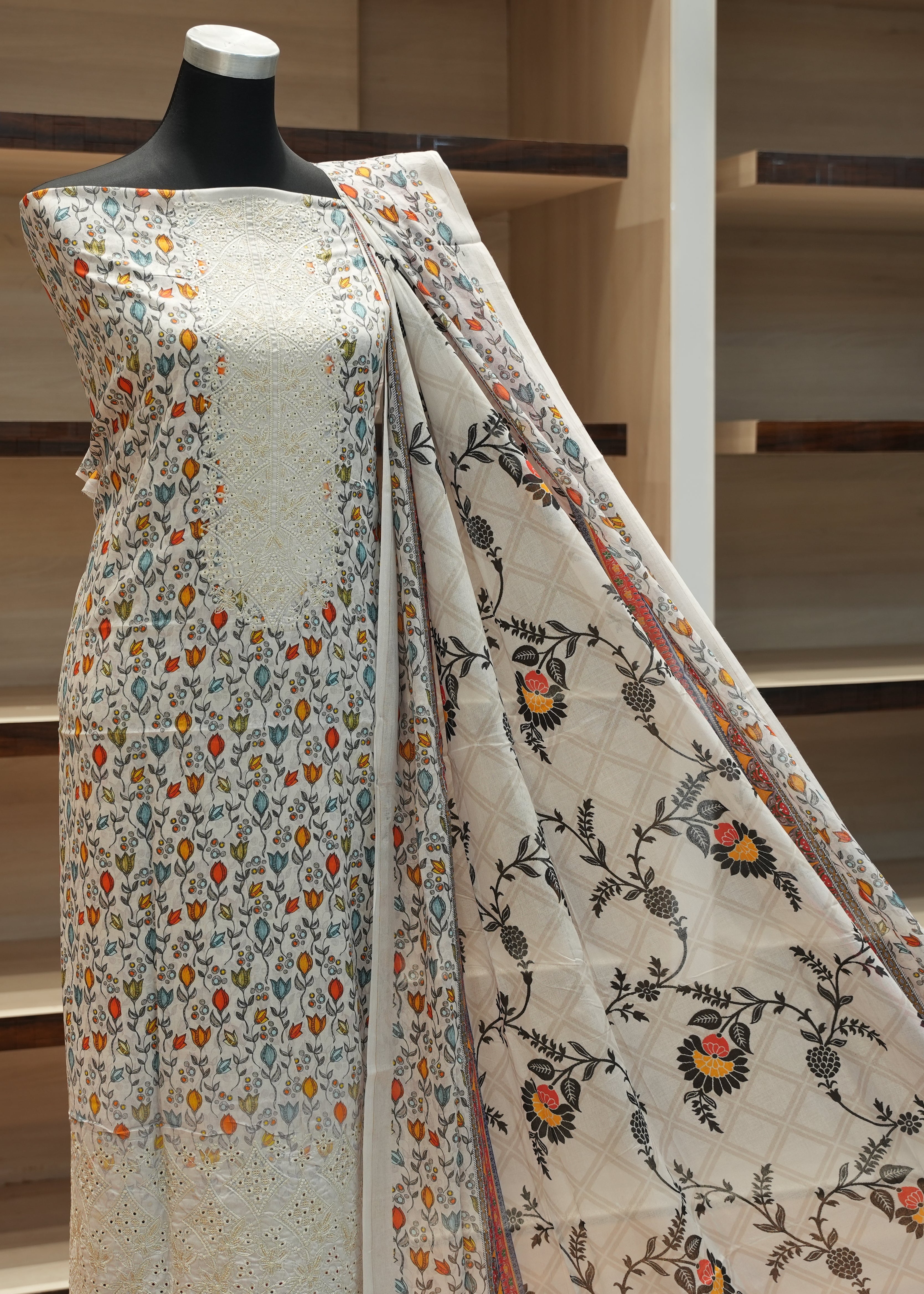 Mannequin wearing a floral-patterned fabric with wooden shelves in the background
