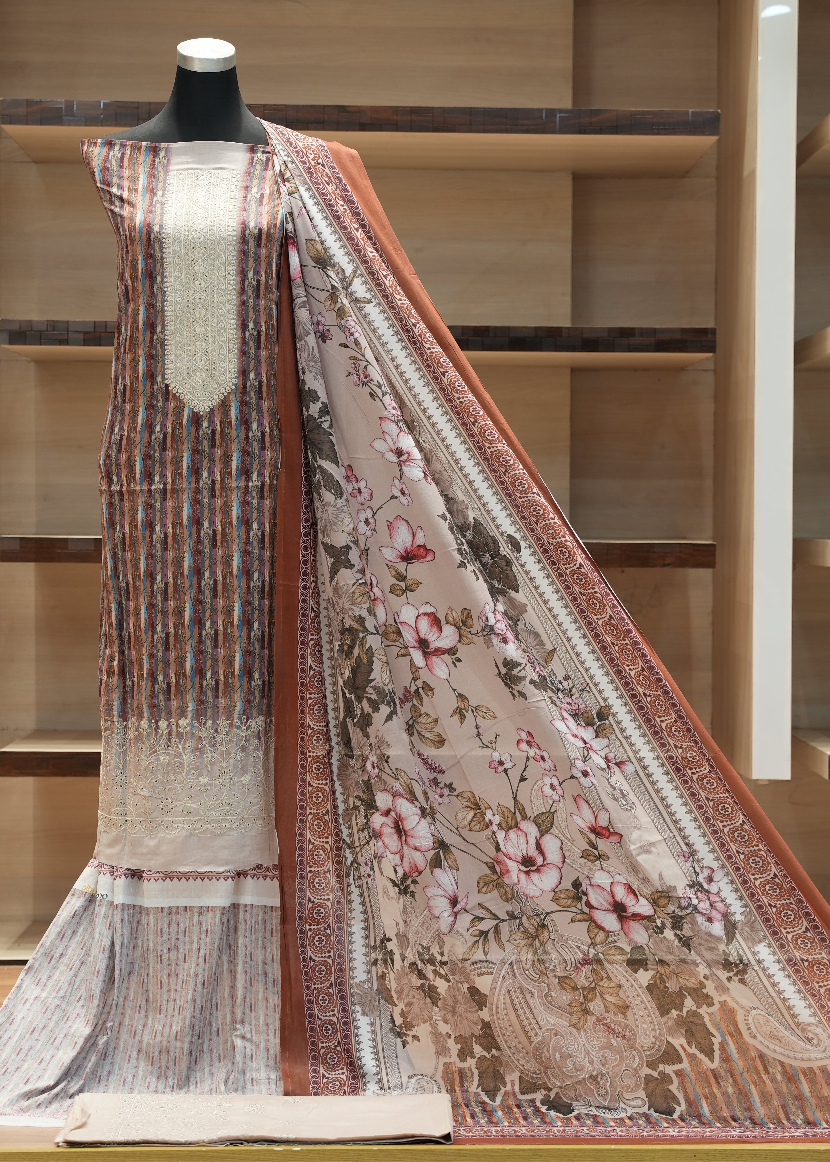Traditional outfit with a floral dupatta on a mannequin against a wooden background