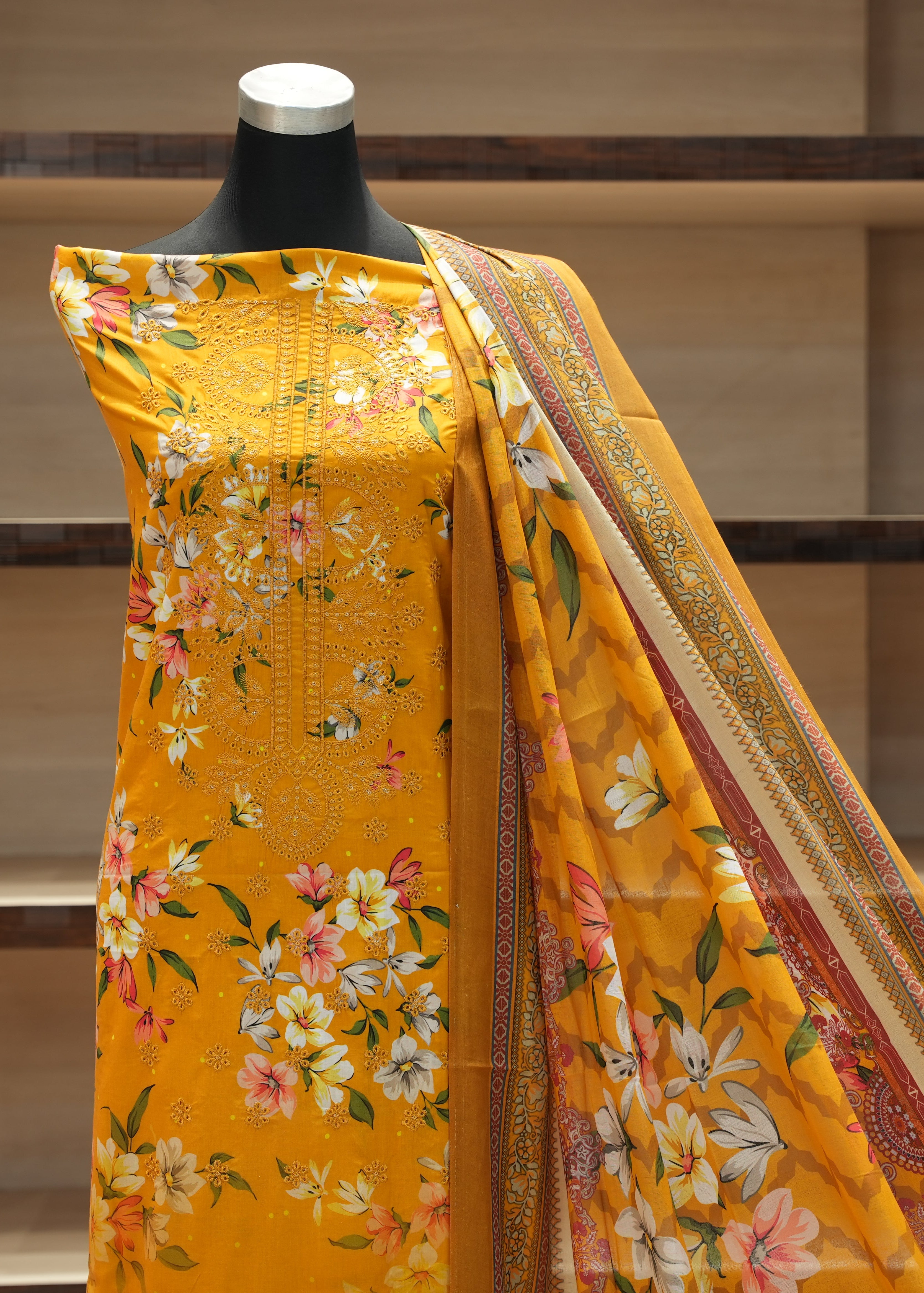 Yellow floral saree on a mannequin against a neutral background