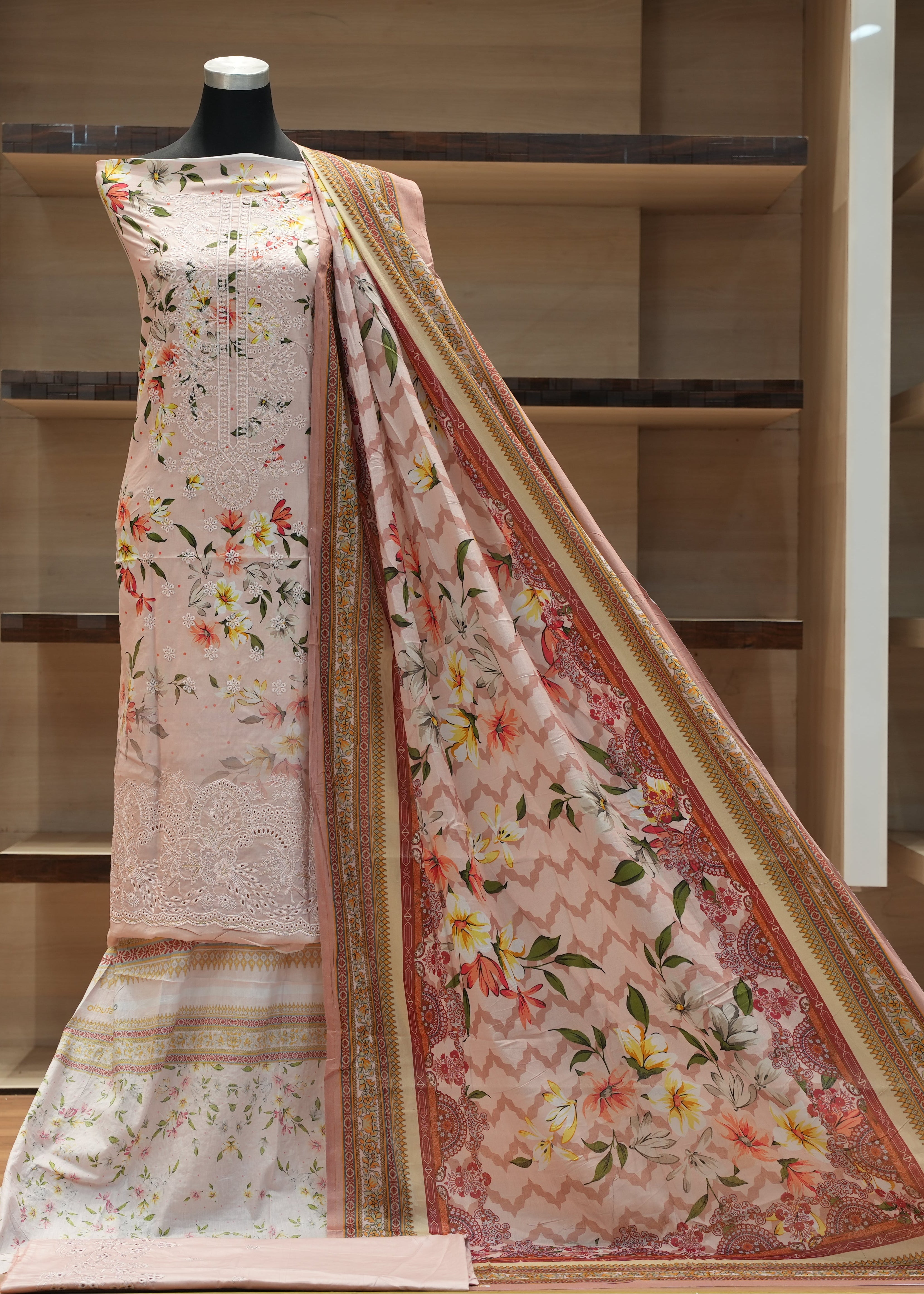 Floral saree with a mannequin against a wooden background