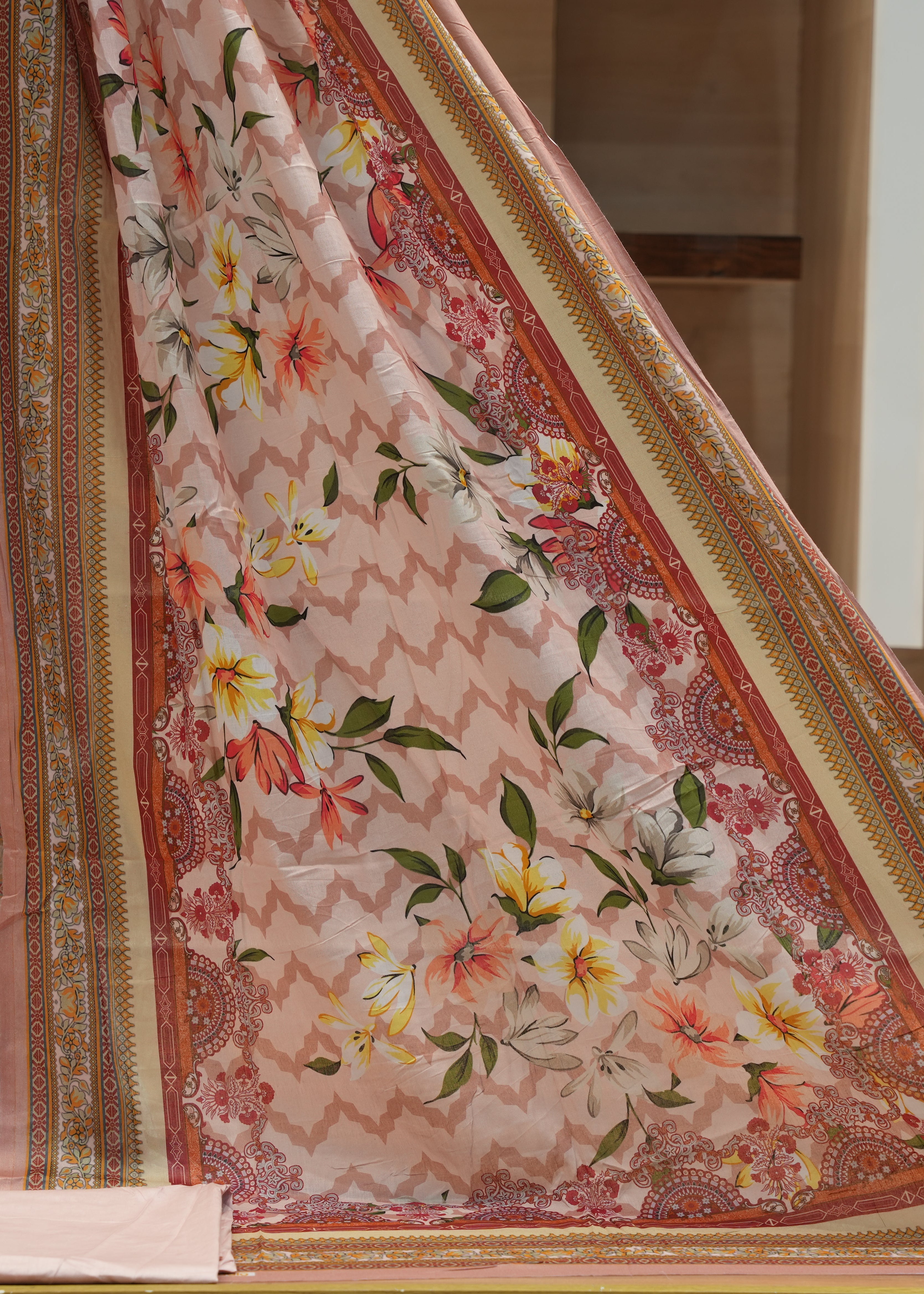 Floral patterned fabric with intricate designs on a wooden surface