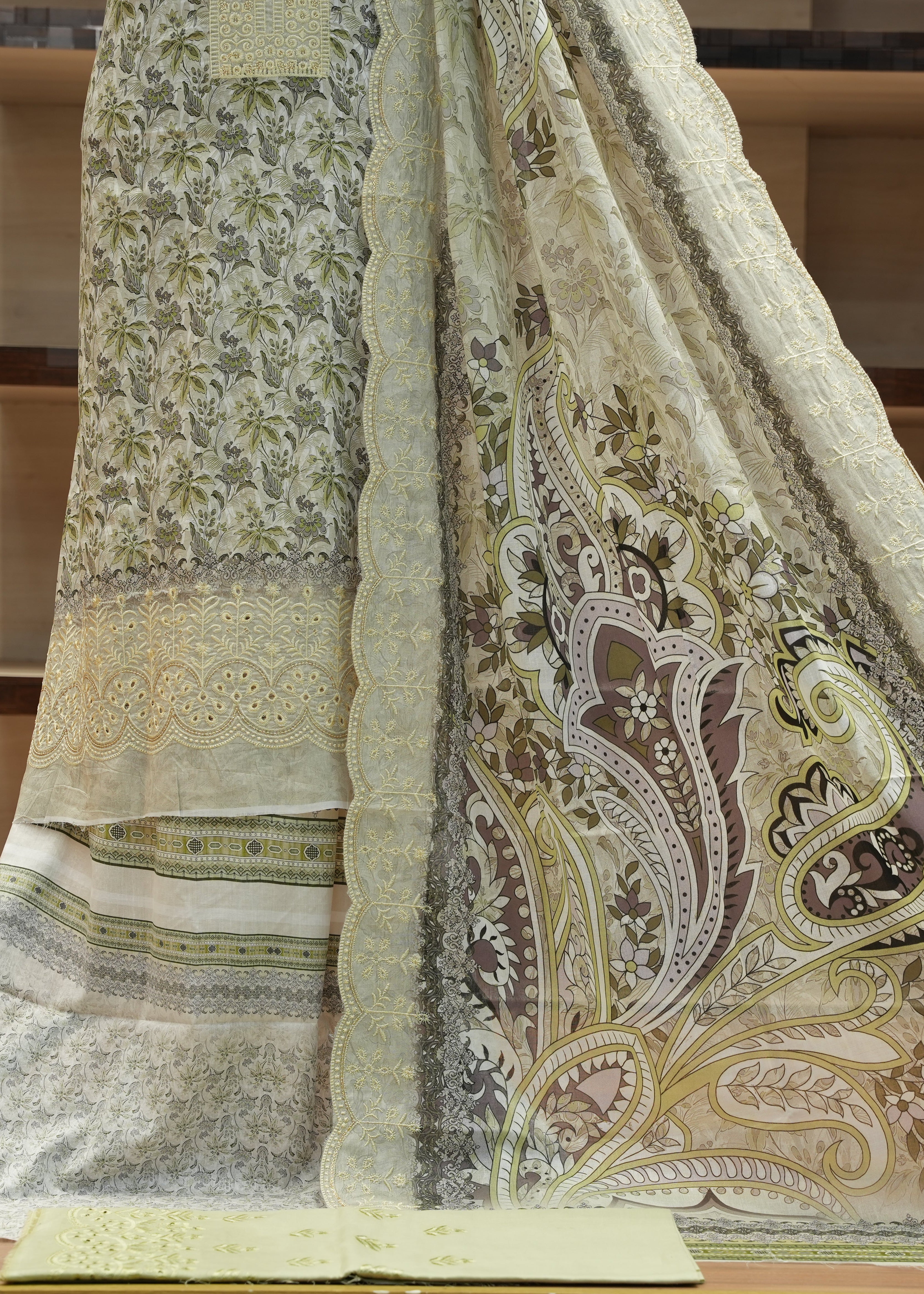 Embroidered fabric with paisley patterns on a wooden surface