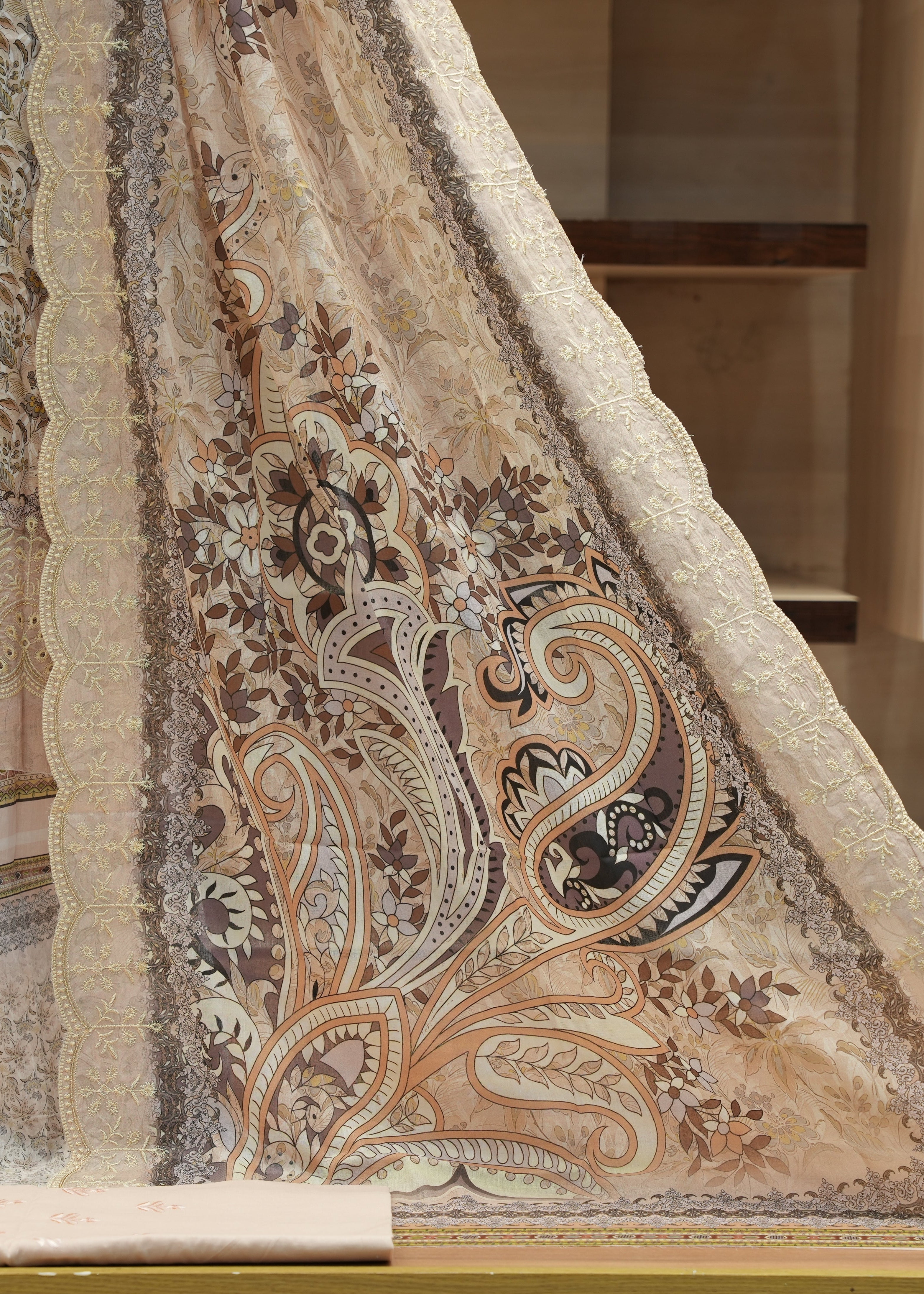 Close-up of a patterned fabric with intricate designs on a neutral background