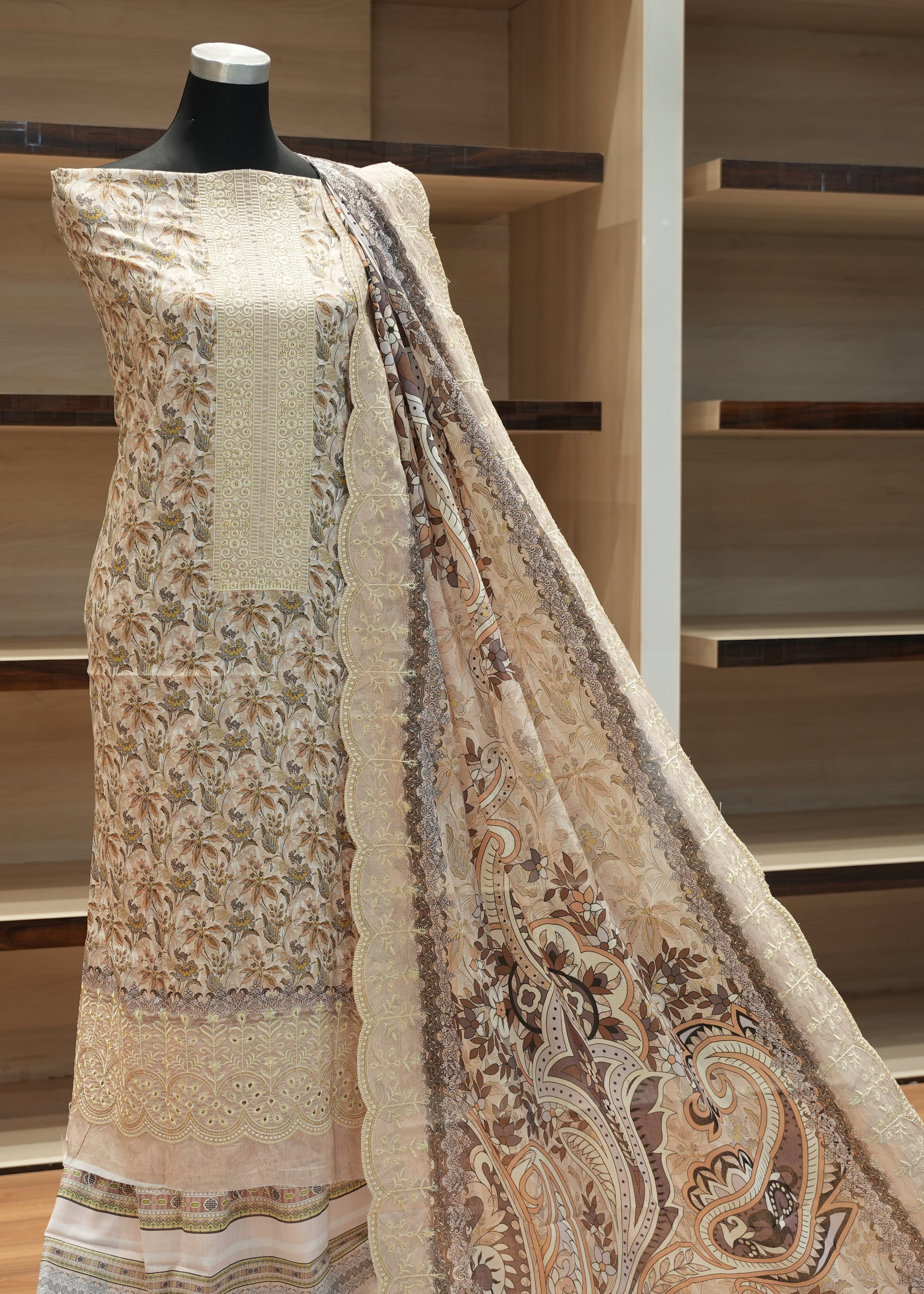 Mannequin wearing a patterned scarf with a wooden shelf background