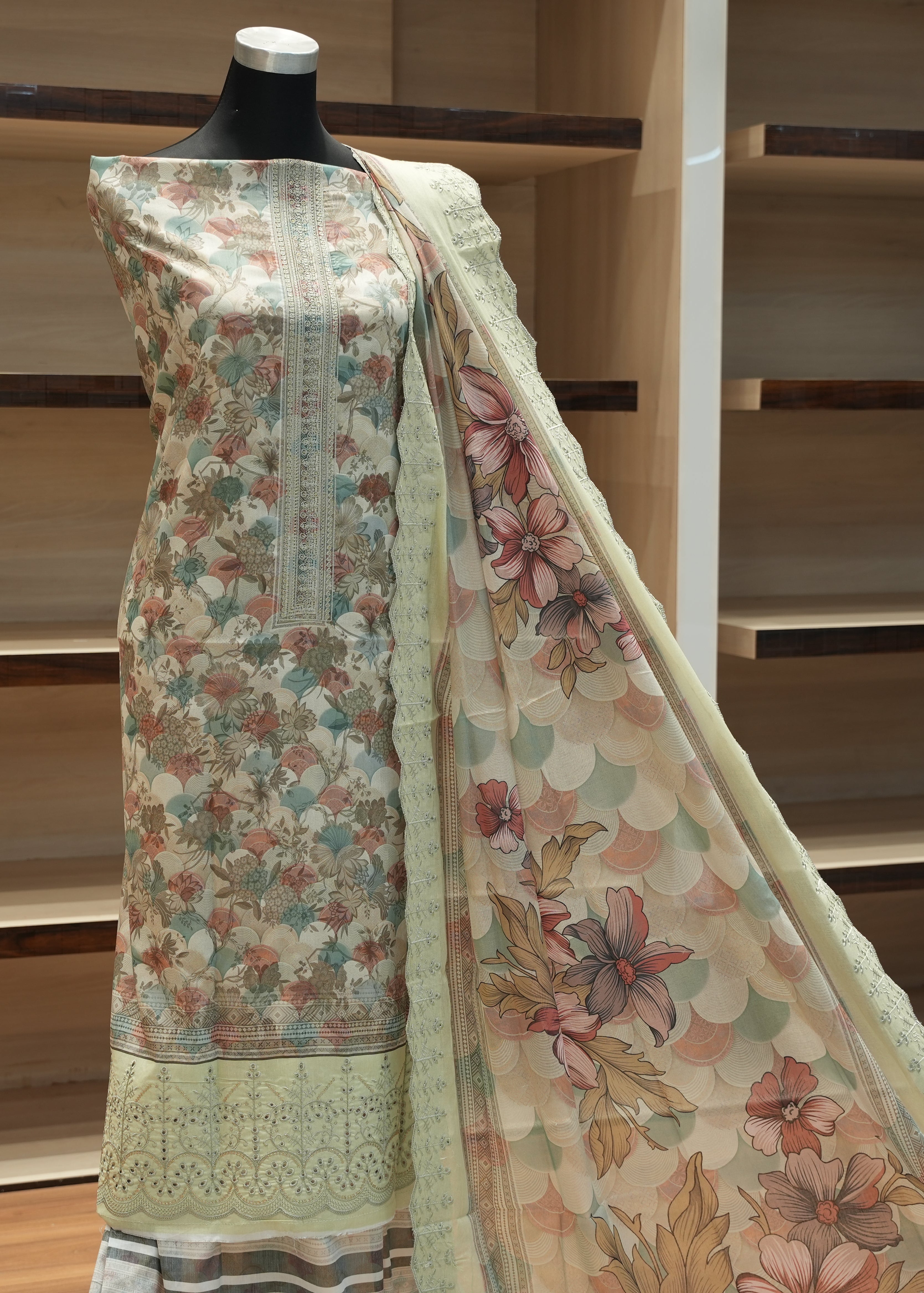 Floral patterned saree on a mannequin against a wooden shelf background