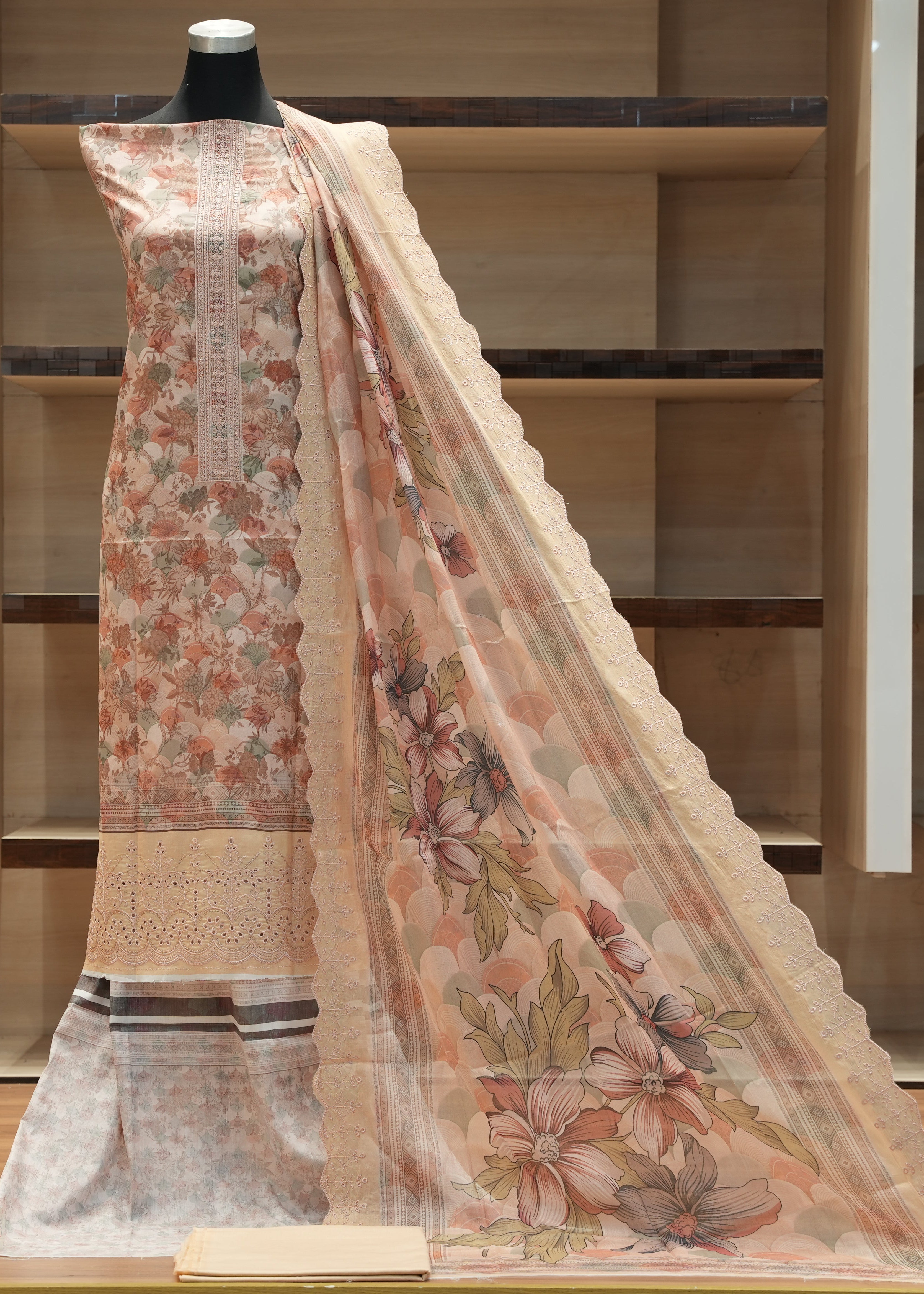 Floral printed saree with a blouse on a mannequin against a wooden shelf background