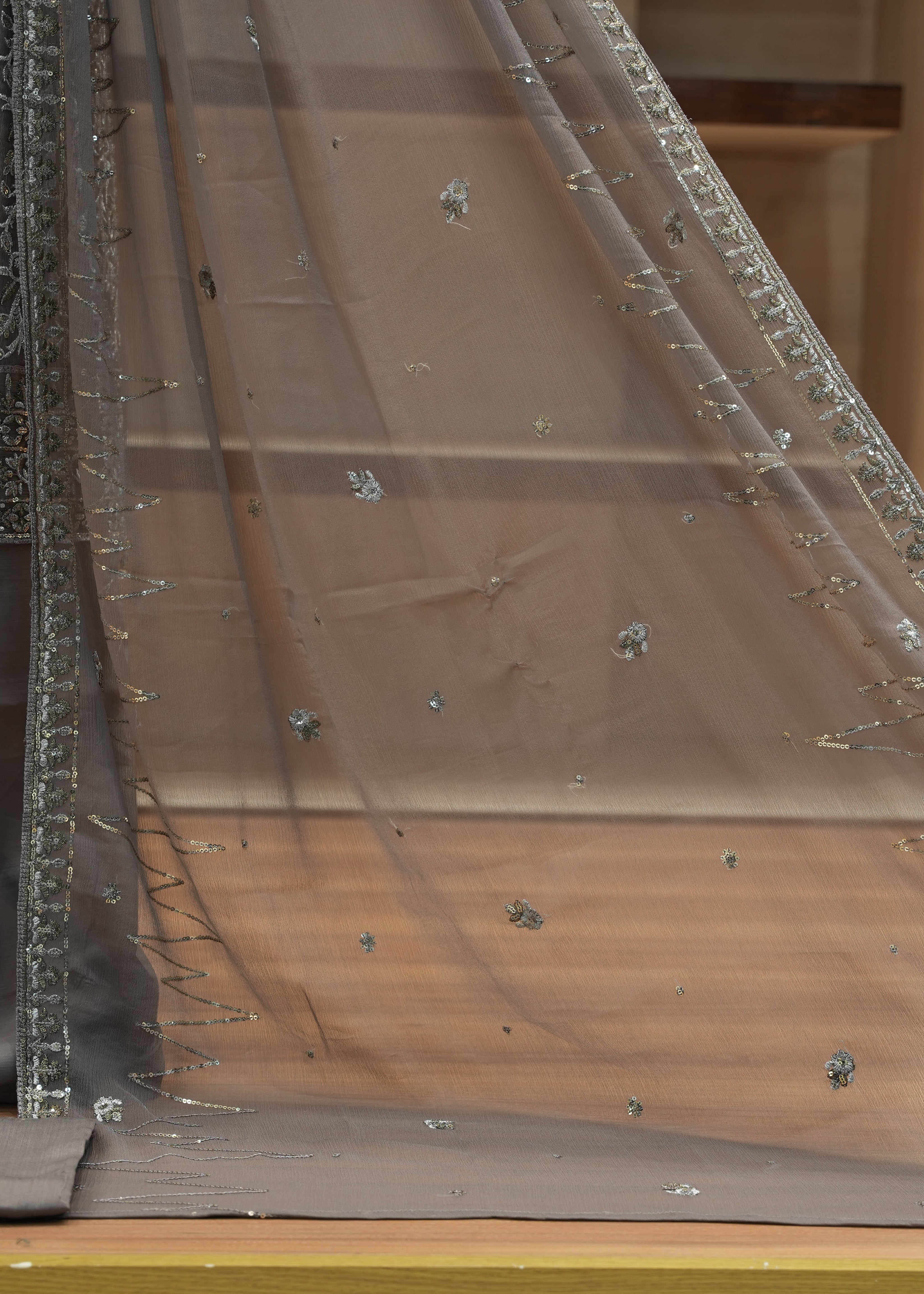 Brown fabric with silver embellishments on a wooden surface