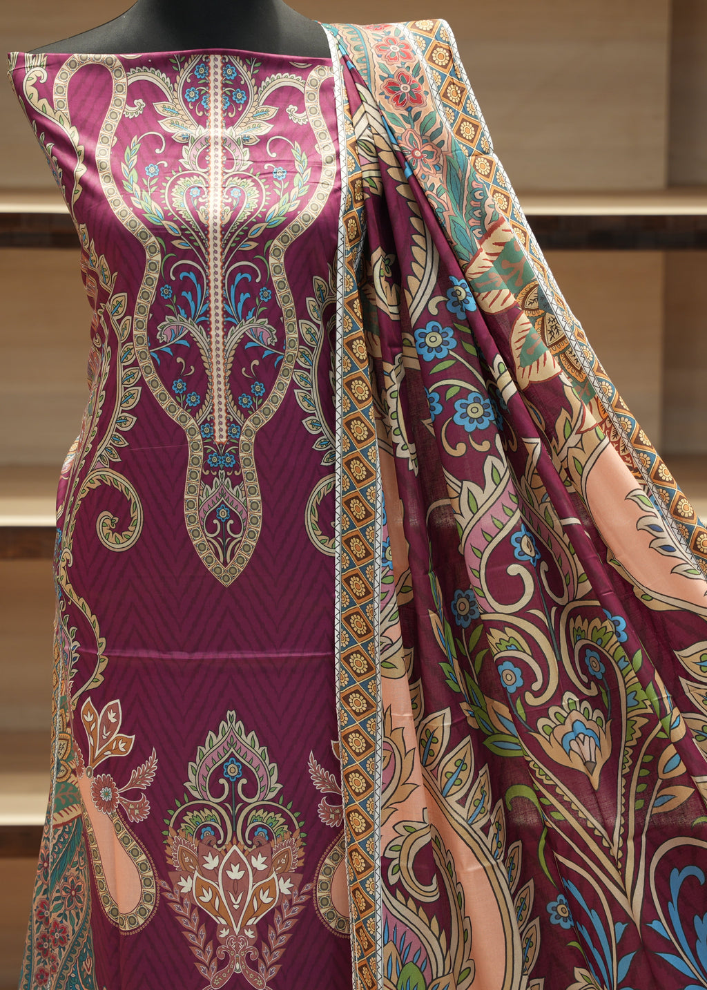 Colorful patterned fabric draped over a mannequin against a neutral background
