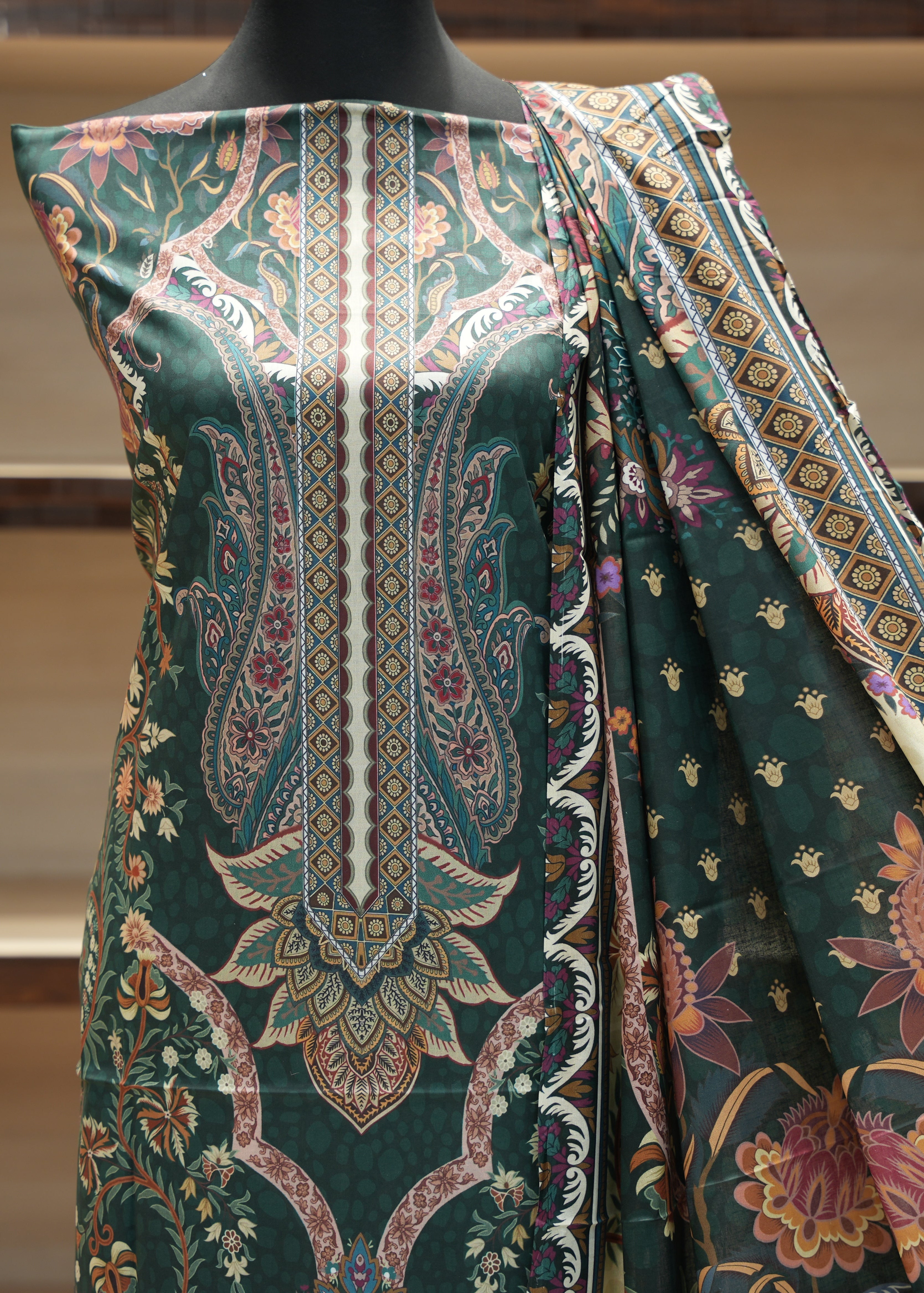 Green patterned fabric on a mannequin with a blurred background