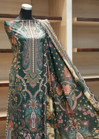 Mannequin wearing a green patterned dress with a wooden background