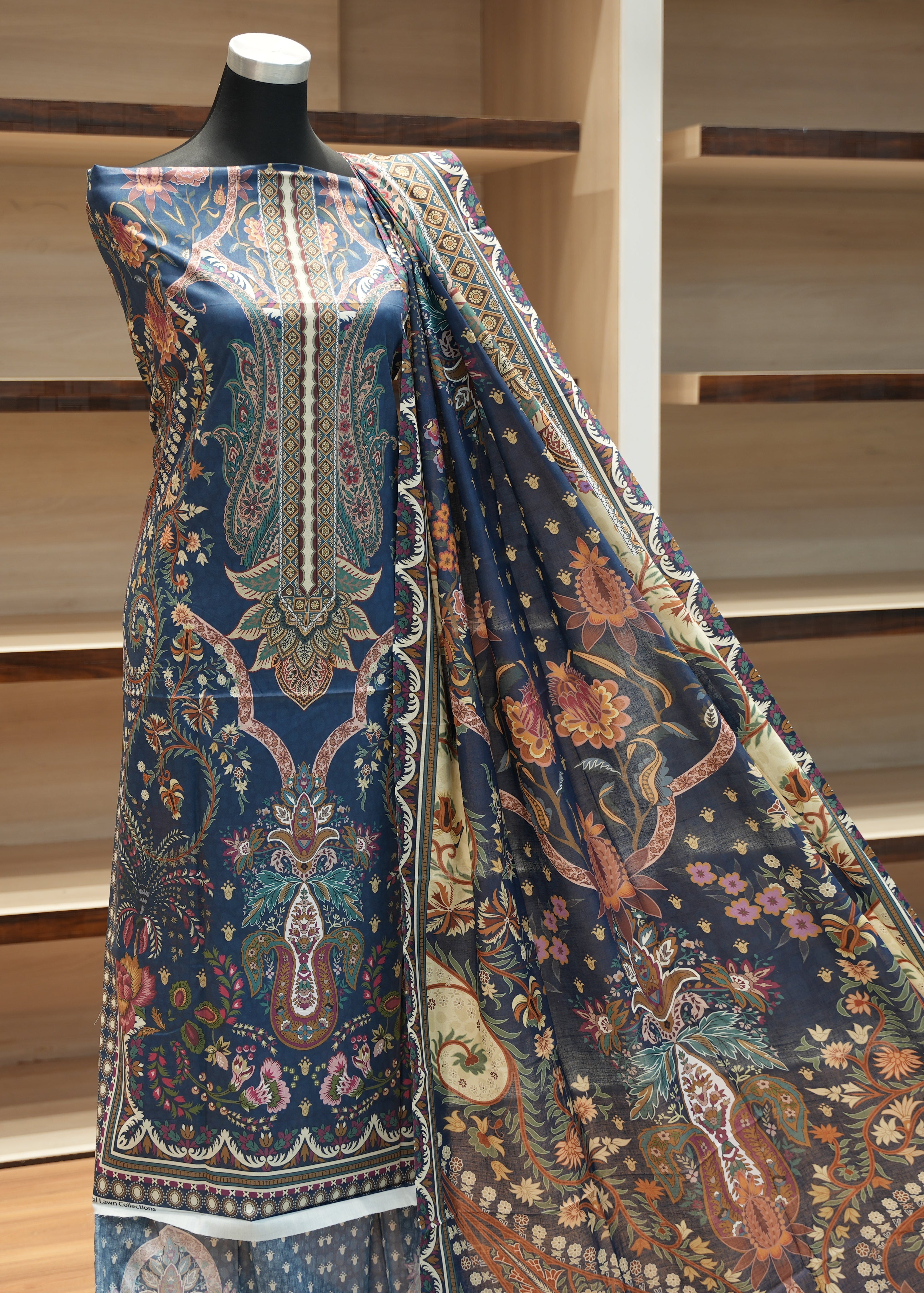 Mannequin wearing a large piece of patterned fabric with a wooden background
