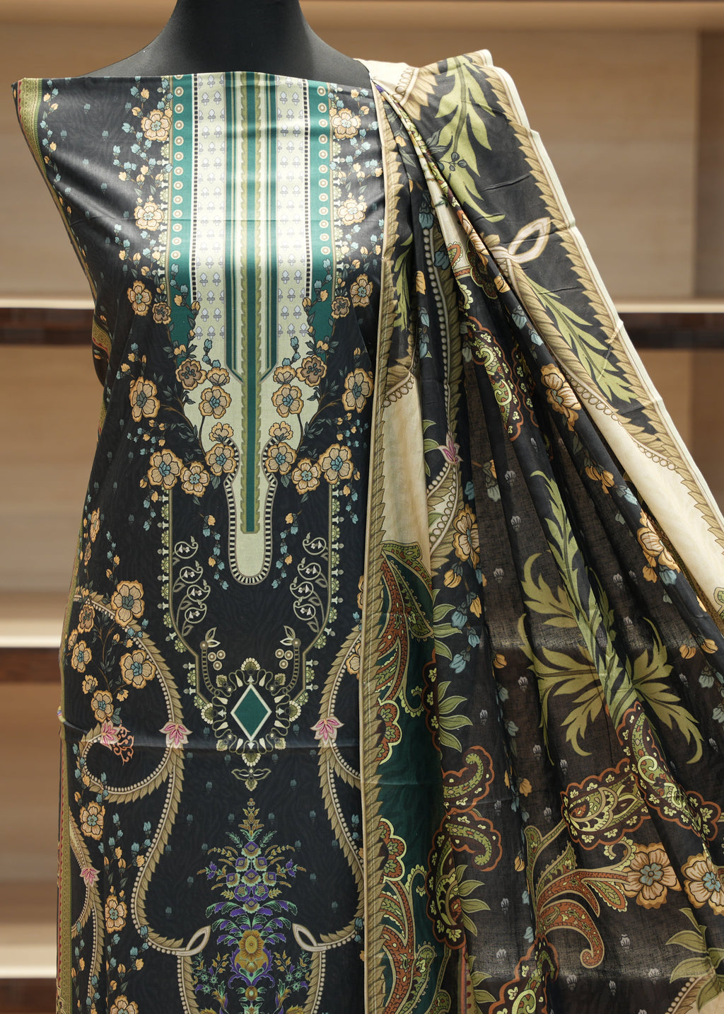 Mannequin wearing a patterned dress with a green and black design.