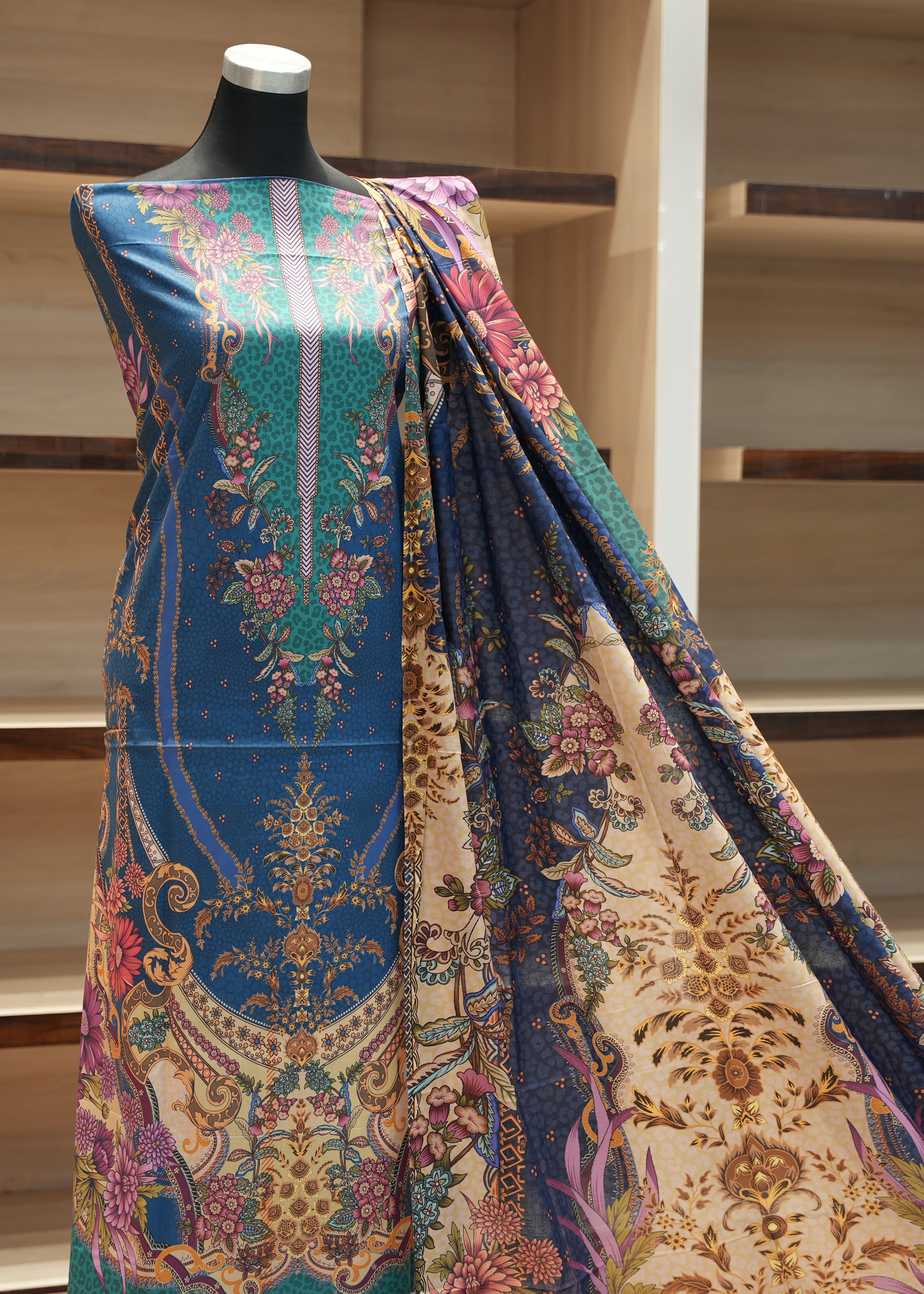 Colorful patterned fabric draped over a mannequin against a wooden staircase background