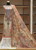 Decorative shawl with intricate patterns on a mannequin against a wooden shelf background