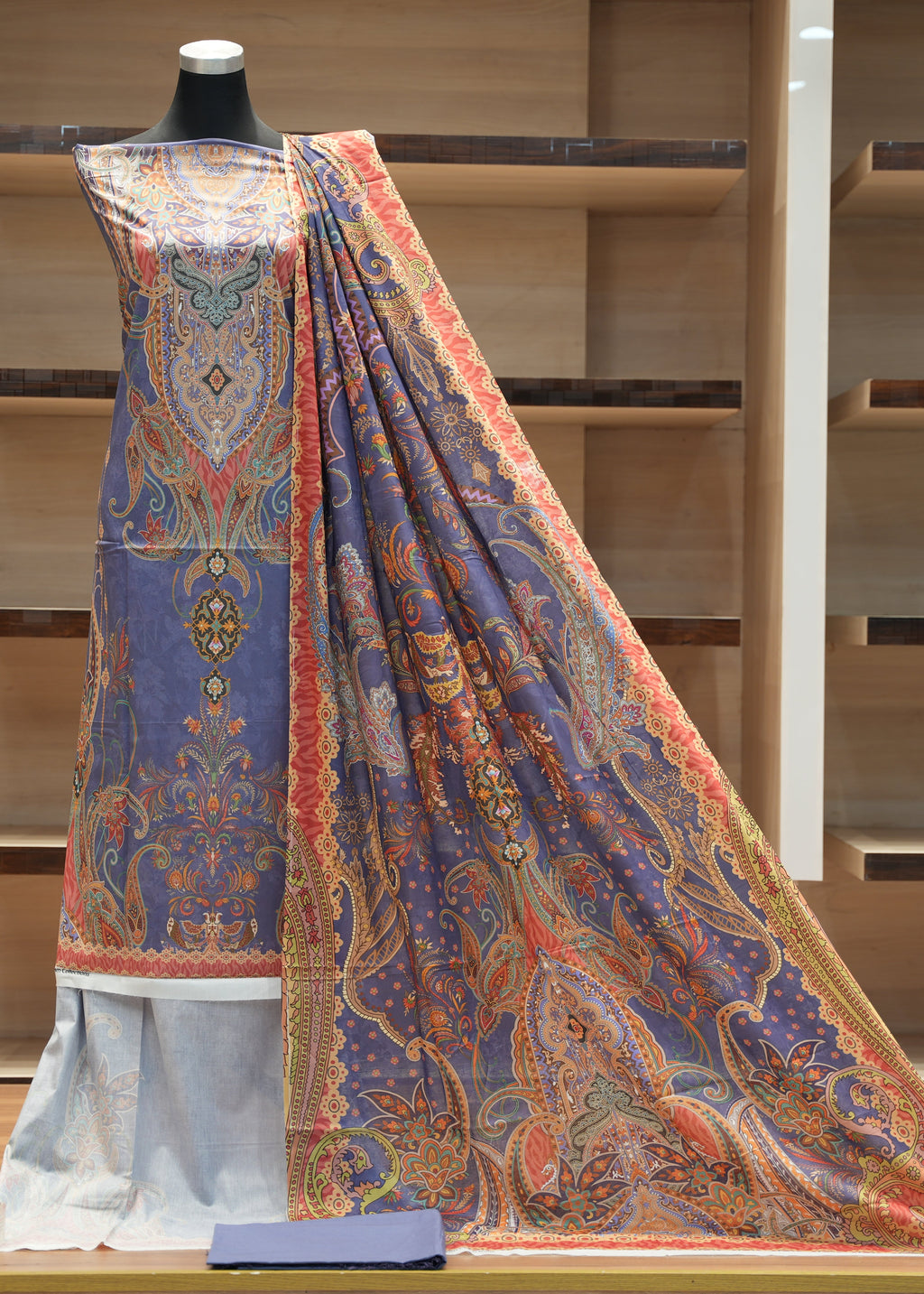Colorful traditional garment on a mannequin against a wooden background