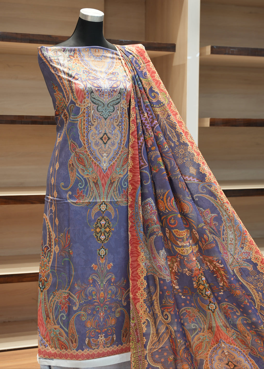 Colorful patterned fabric draped over a mannequin against a wooden background