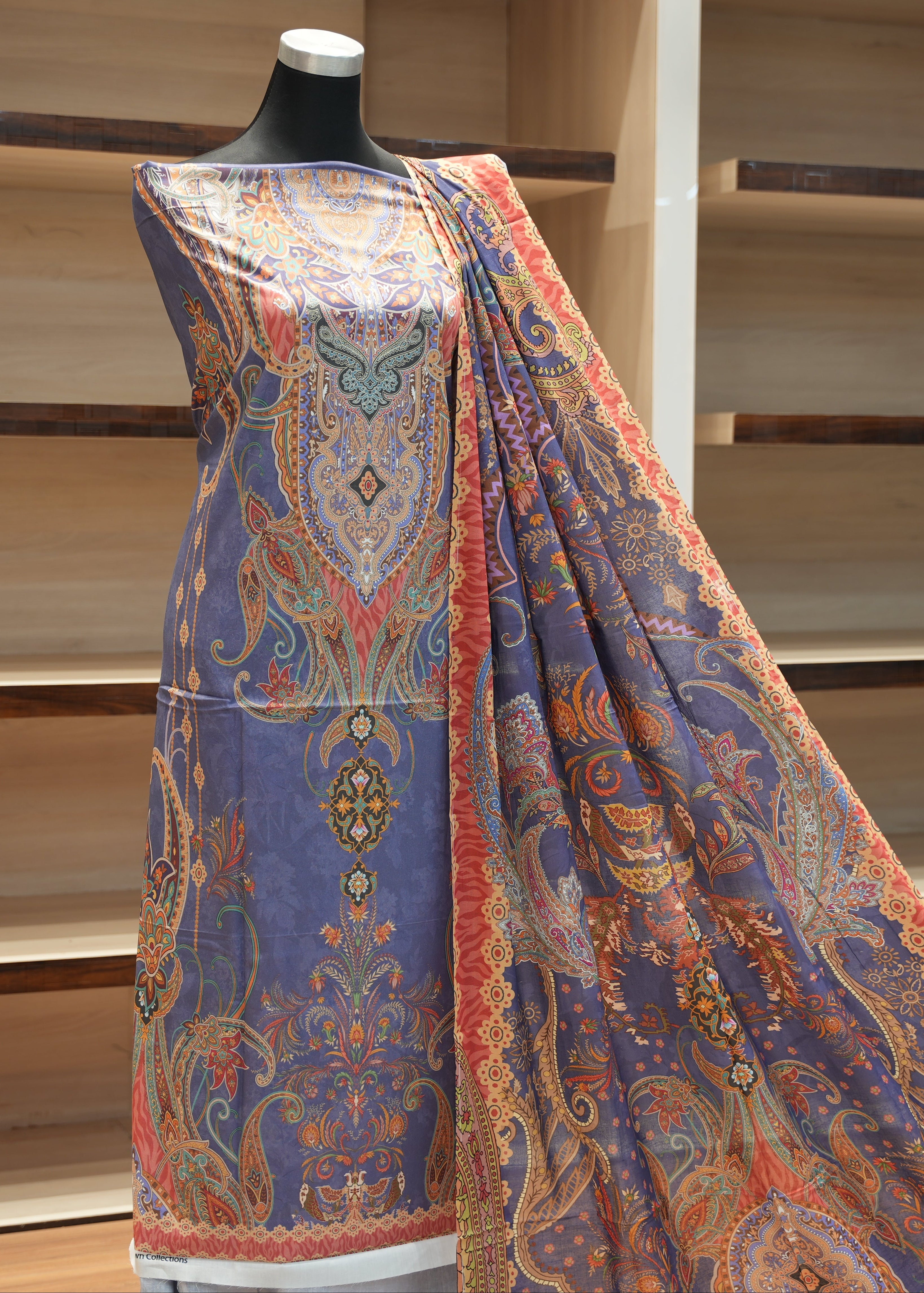 Colorful patterned fabric draped over a mannequin against a wooden background