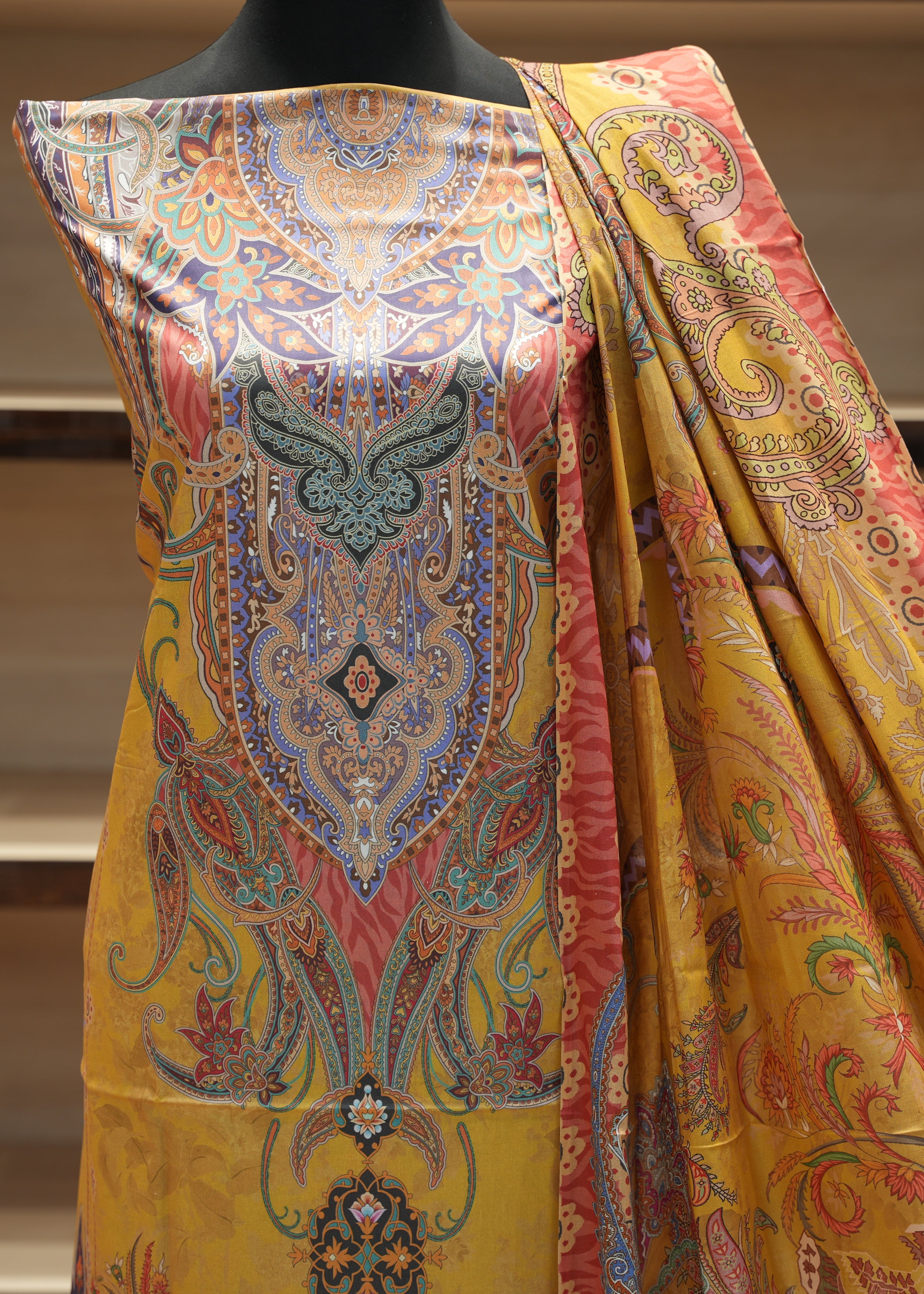 Colorful patterned fabric draped over a mannequin against a neutral background