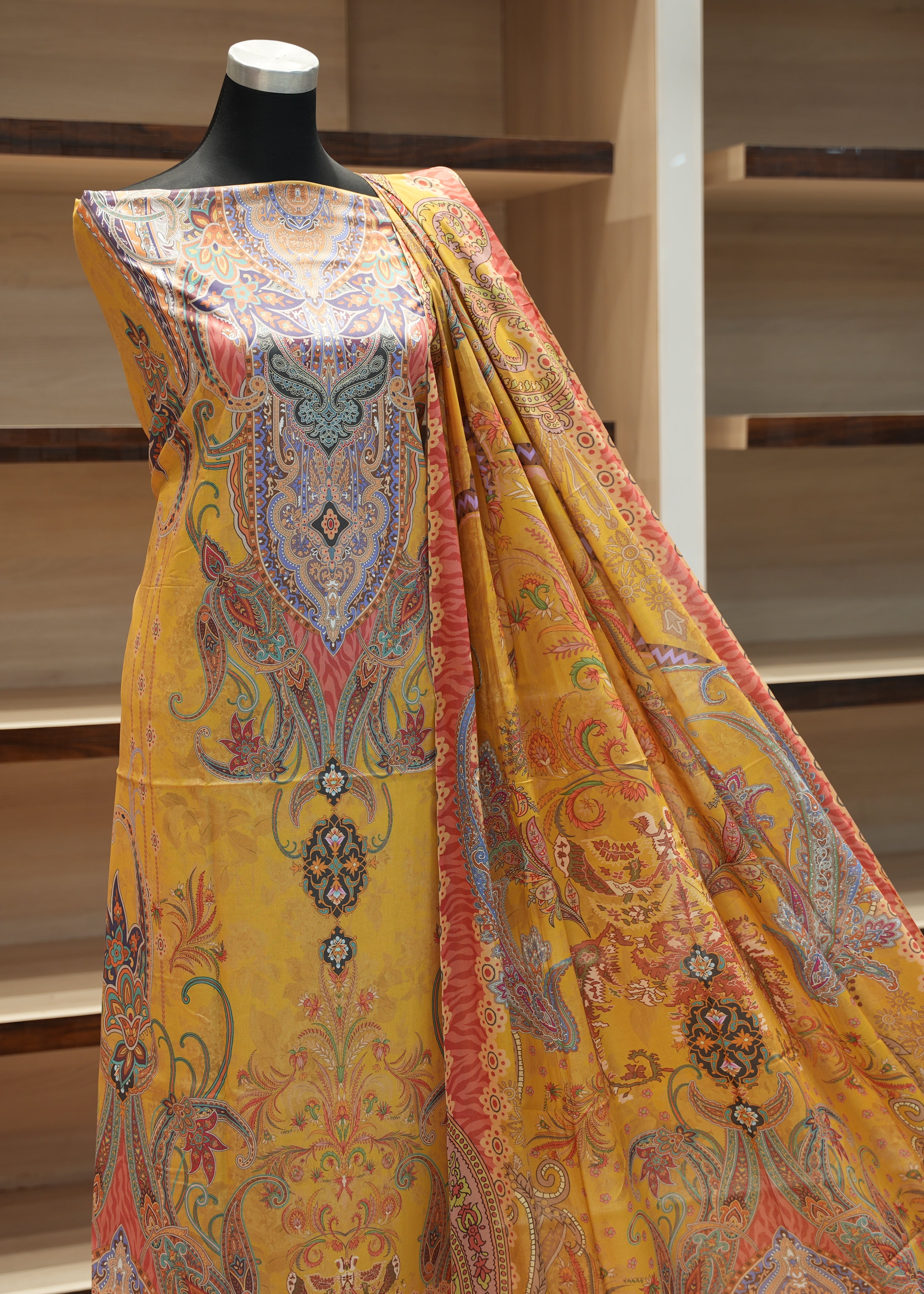 Colorful patterned fabric draped over a mannequin against a wooden background