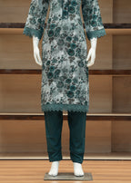 Mannequin wearing a floral dress and pants in front of a wooden shelf.