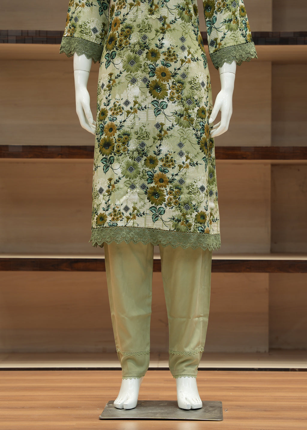 Mannequin wearing a floral dress and pants in a minimalistic setting