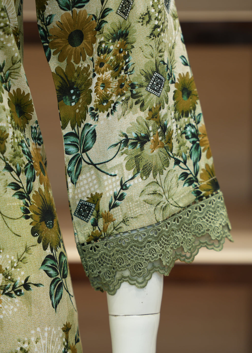 Floral-patterned garment with lace trim on a mannequin against a blurred background