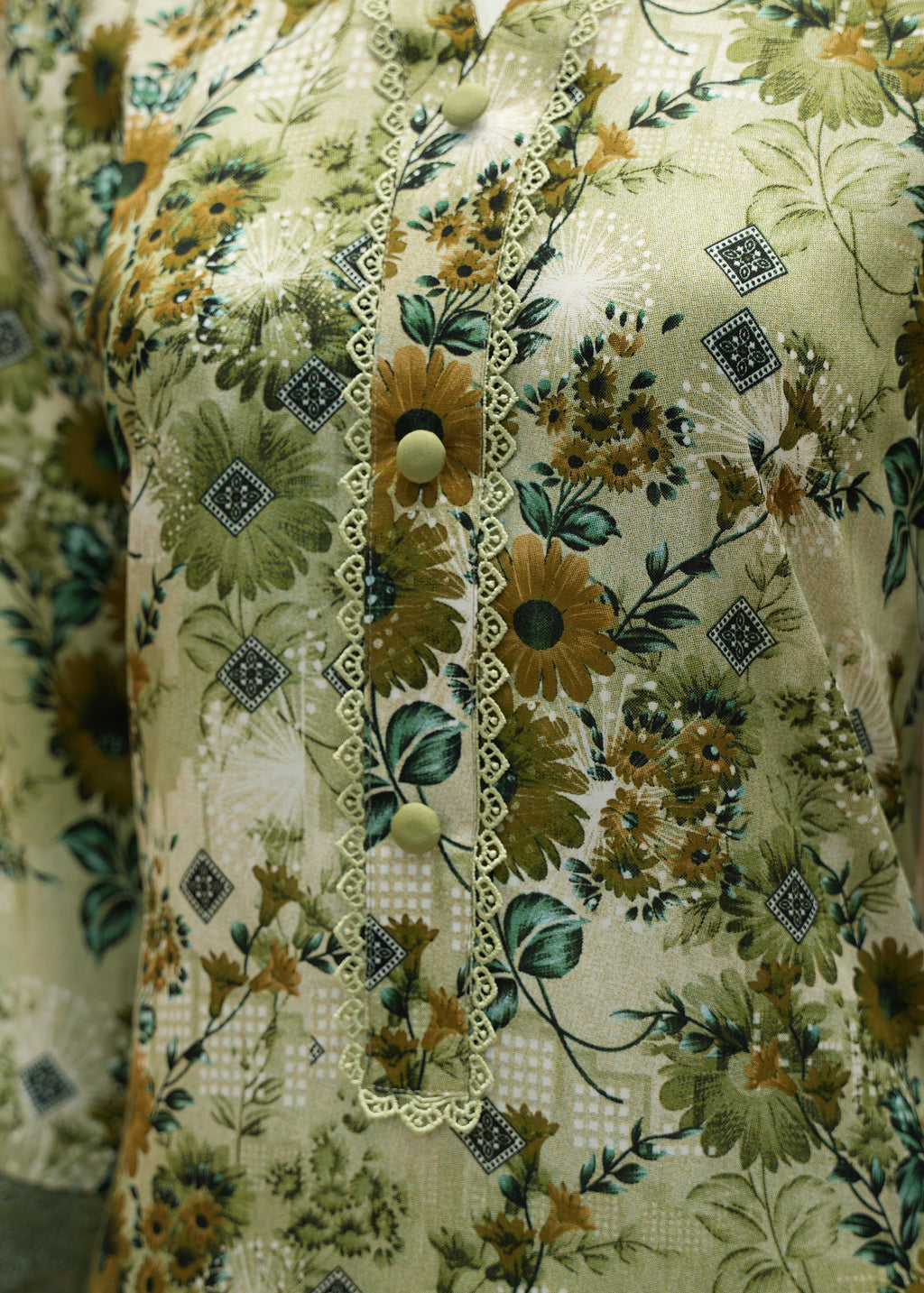 Close-up of a floral dress with green and brown colors.