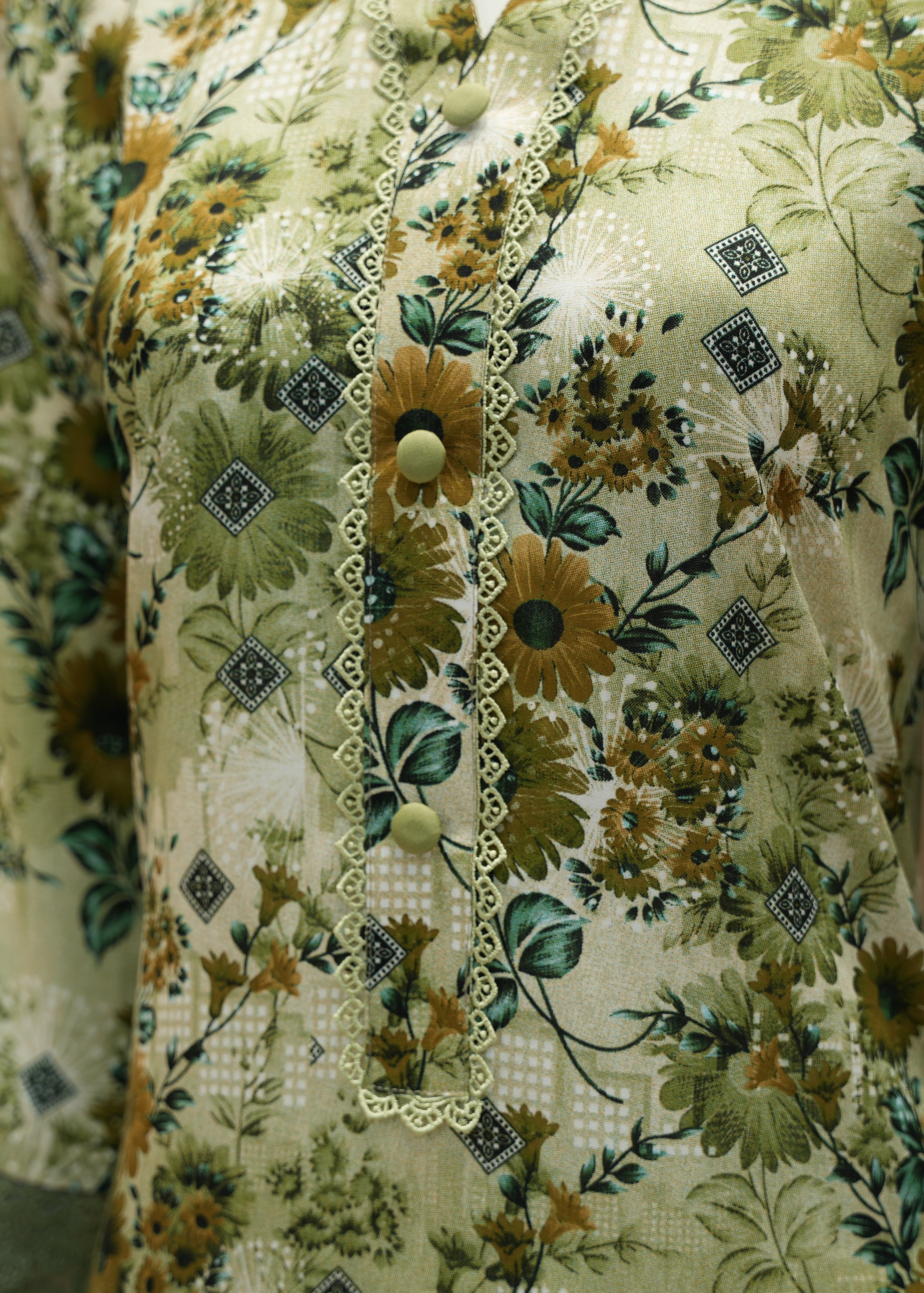 Close-up of a floral dress with green and brown colors.