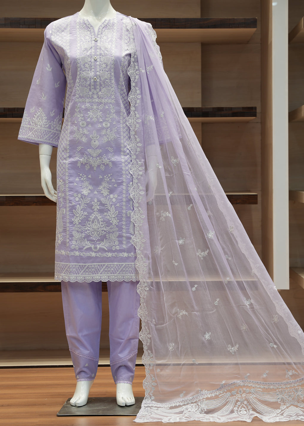 Lavender embroidered outfit with a matching dupatta on a mannequin against a wooden background