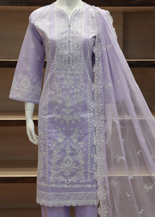 Lavender embroidered outfit with a dupatta on a mannequin against a wooden shelf background