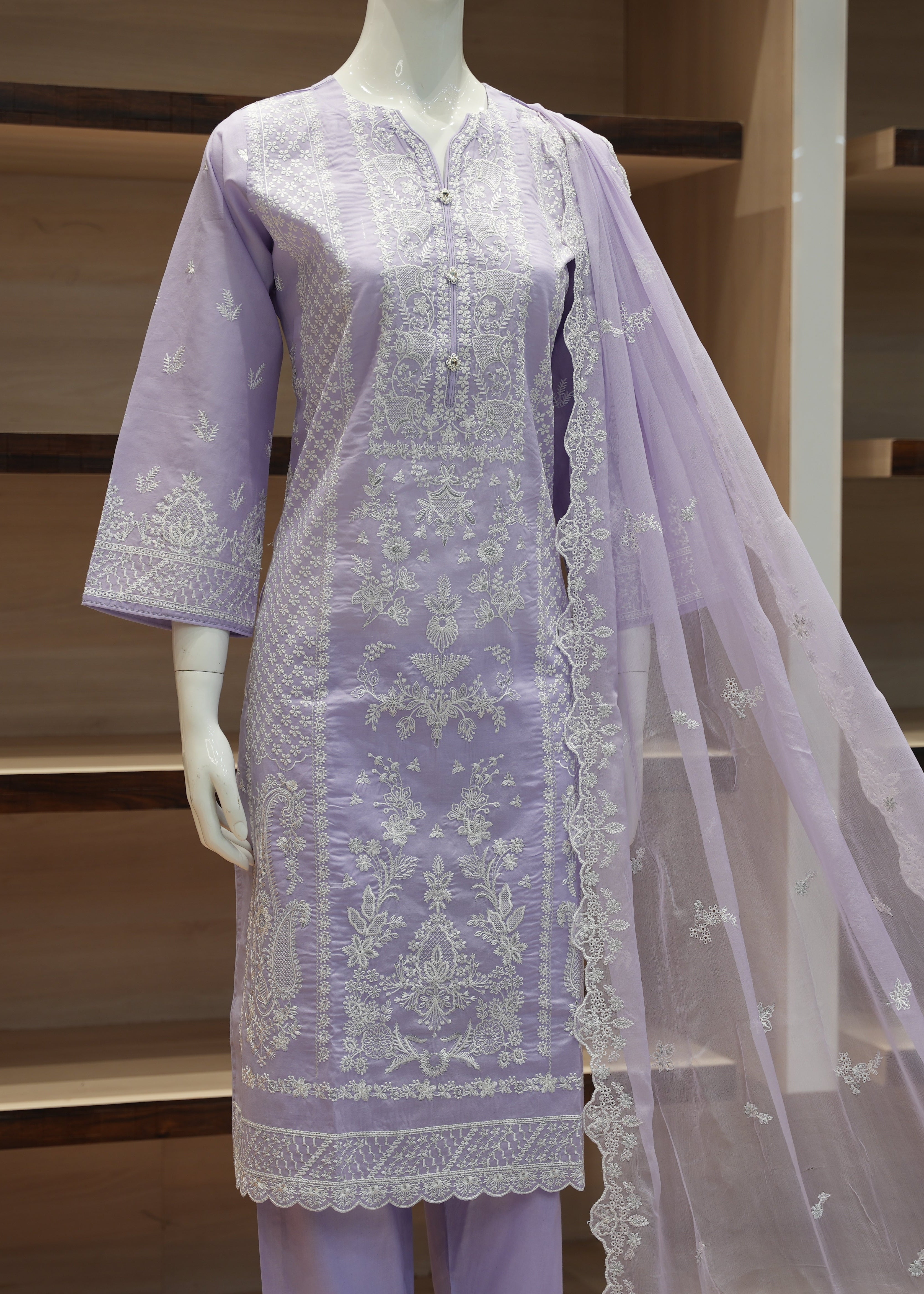 Lavender embroidered outfit with a dupatta on a mannequin against a wooden background