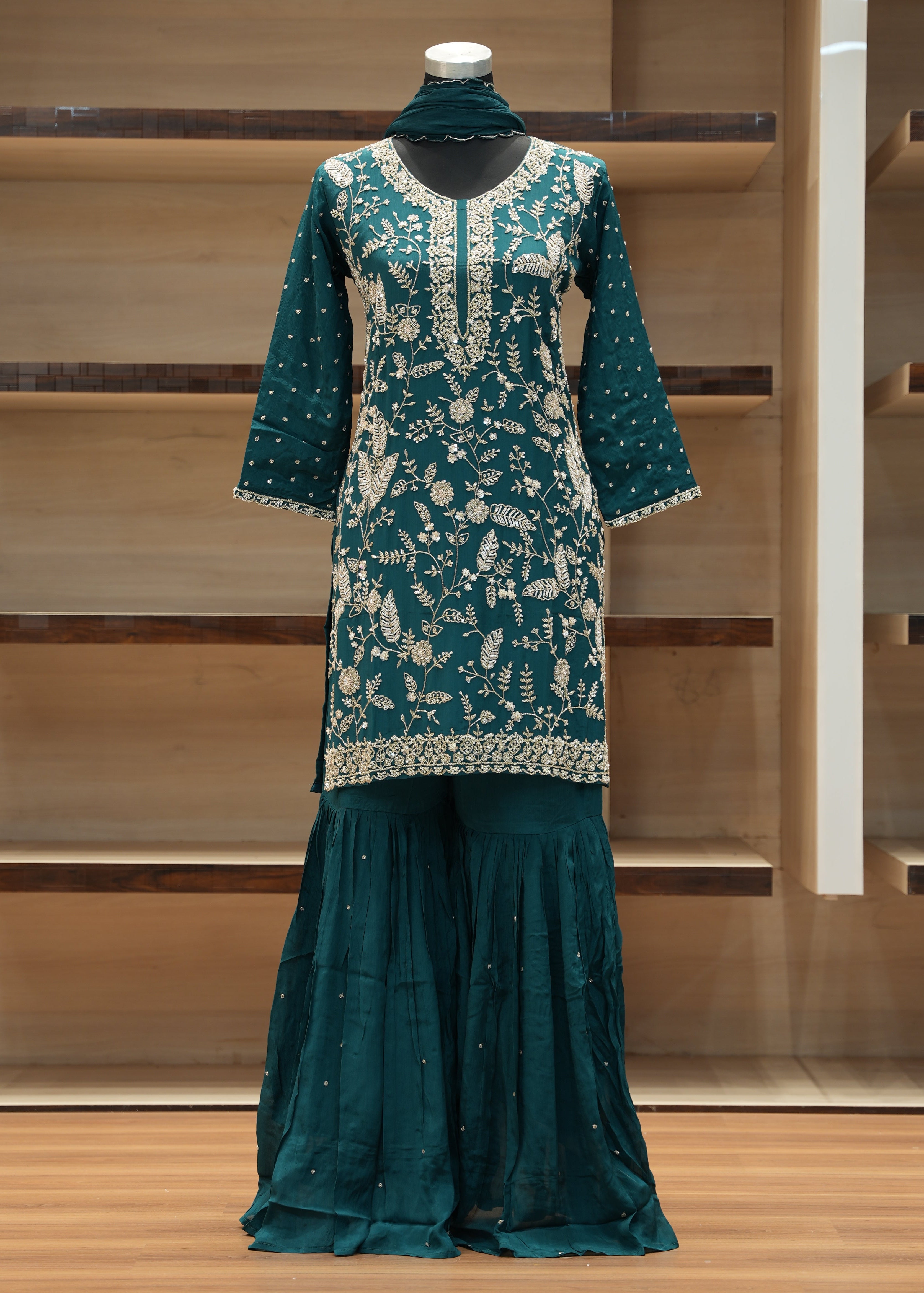Green dress with white floral pattern on a wooden rack