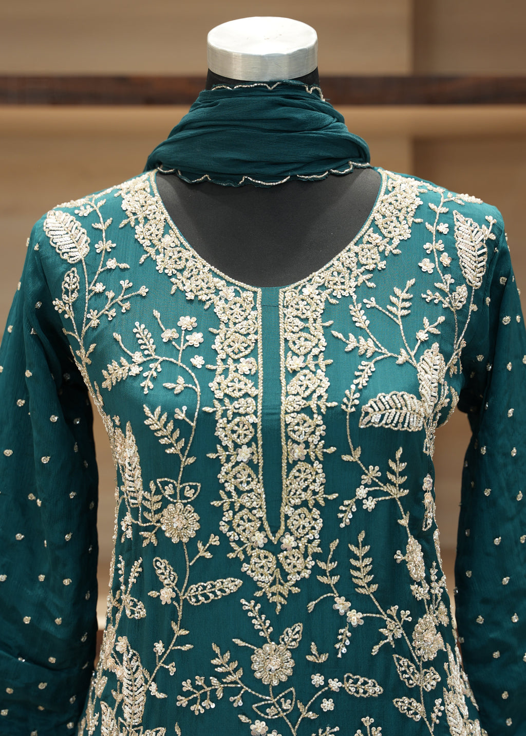Teal fabric with white floral pattern on a mannequin against a neutral background