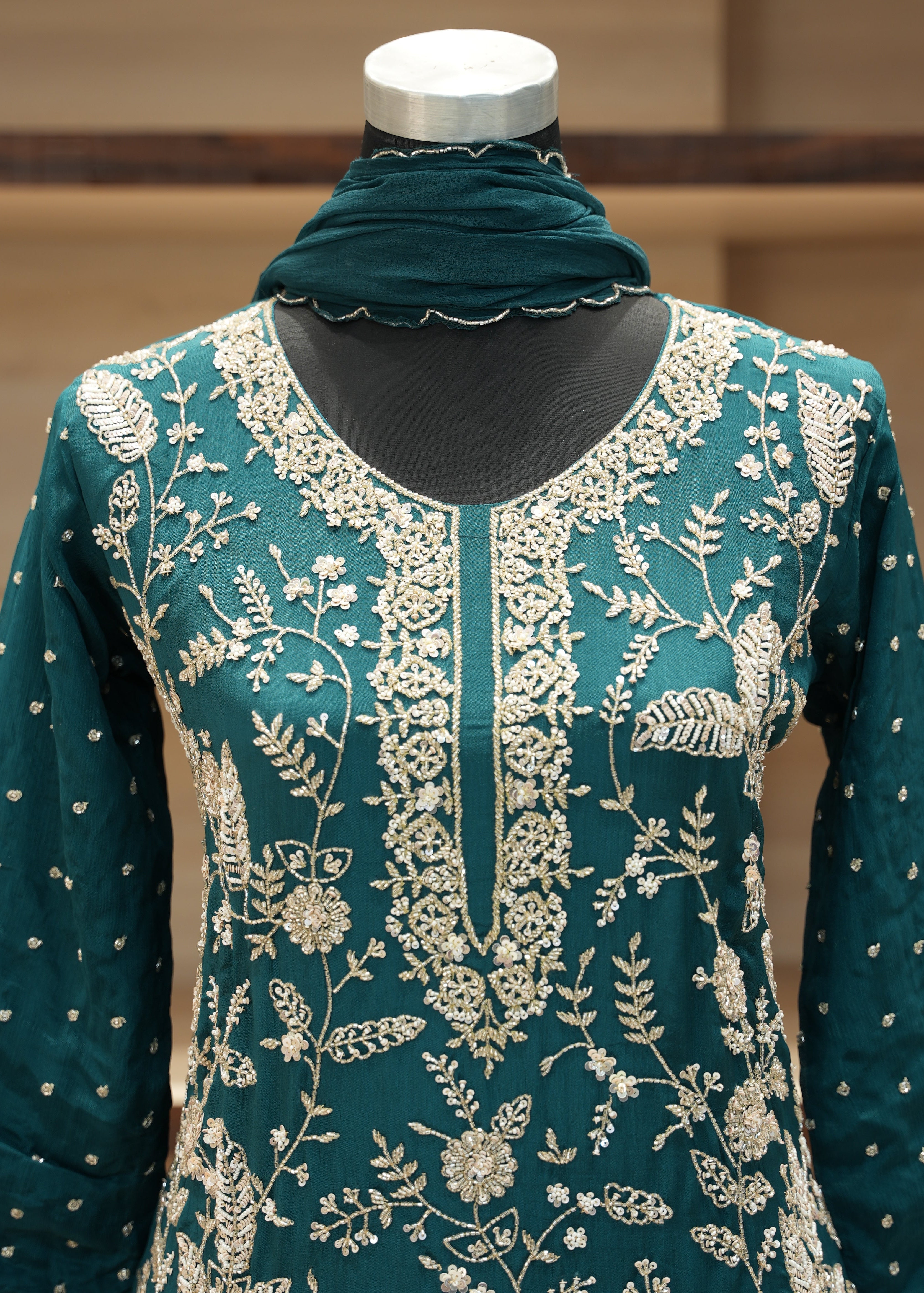 Teal fabric with white floral pattern on a mannequin against a neutral background