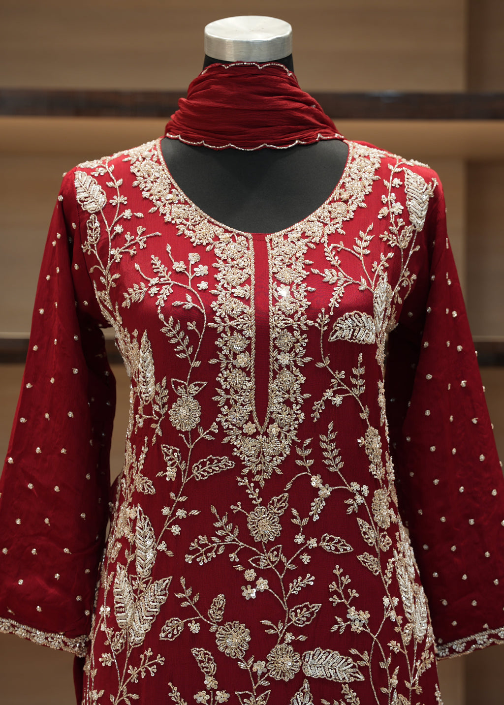Red embroidered dress on a mannequin with a blurred background