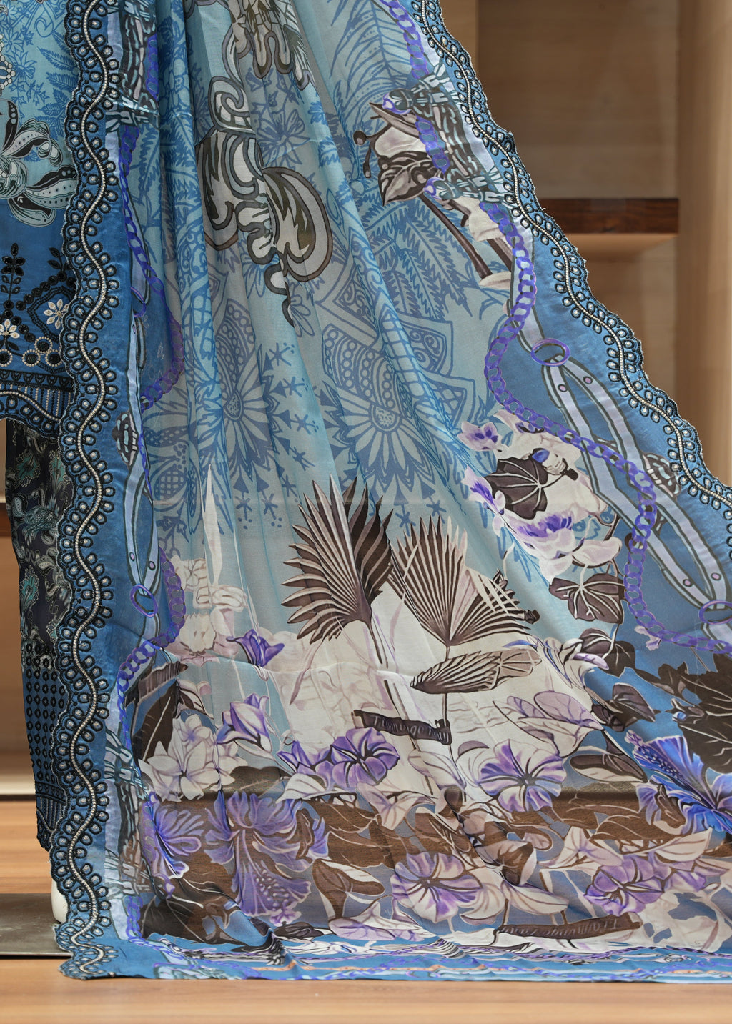 Blue and patterned fabric with a person wearing a matching outfit in a room.