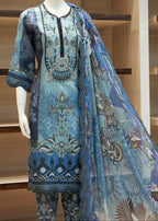 Mannequin wearing a blue embroidered outfit with a matching dupatta against a wooden background