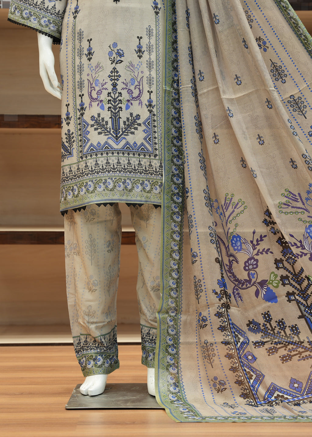 Traditional outfit with embroidered top, pants, and dupatta on a wooden stand.