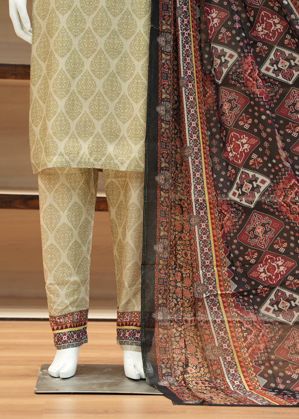 Traditional outfit with a patterned dupatta on a wooden floor