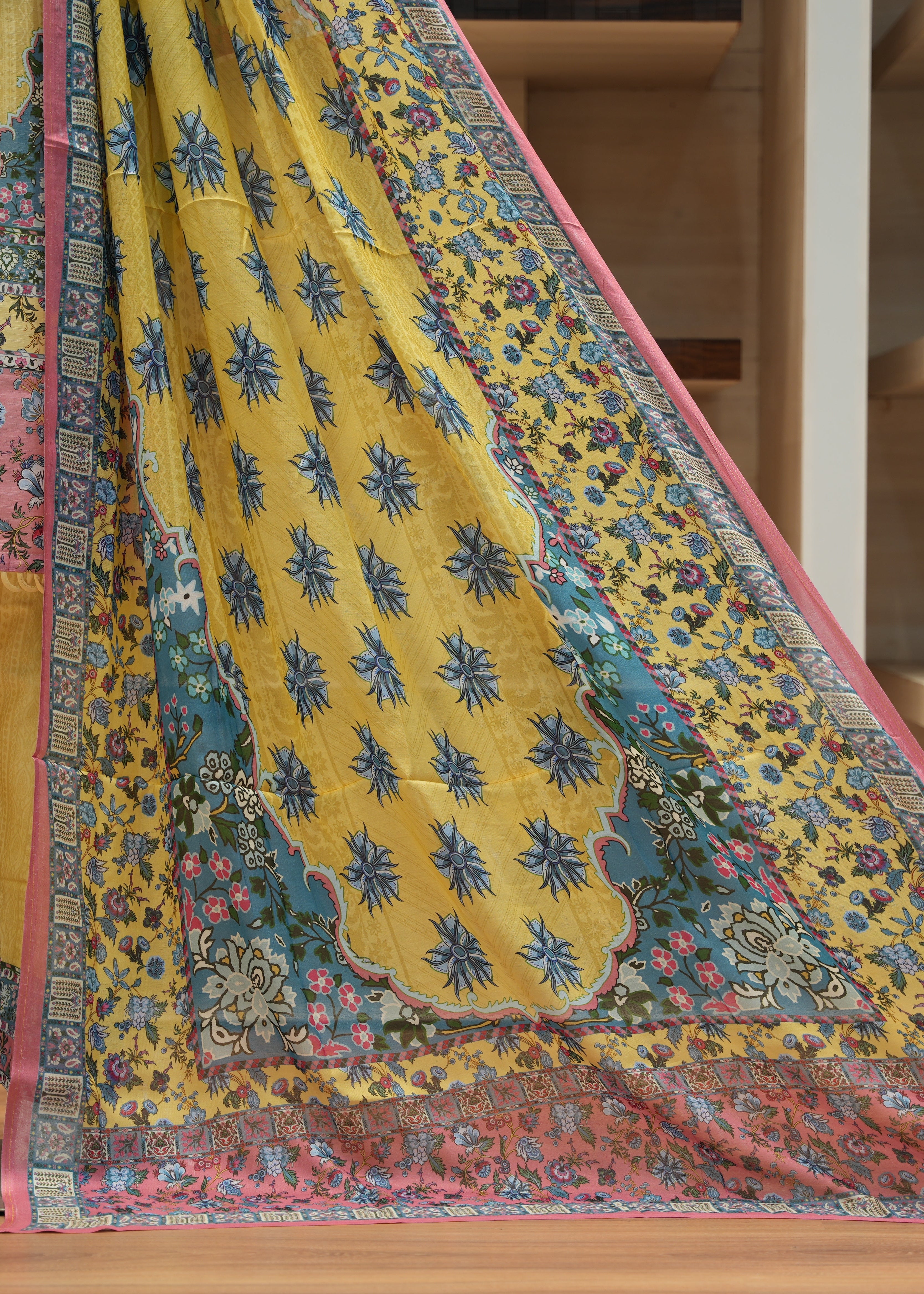 Colorful traditional fabric with intricate patterns on a wooden floor.